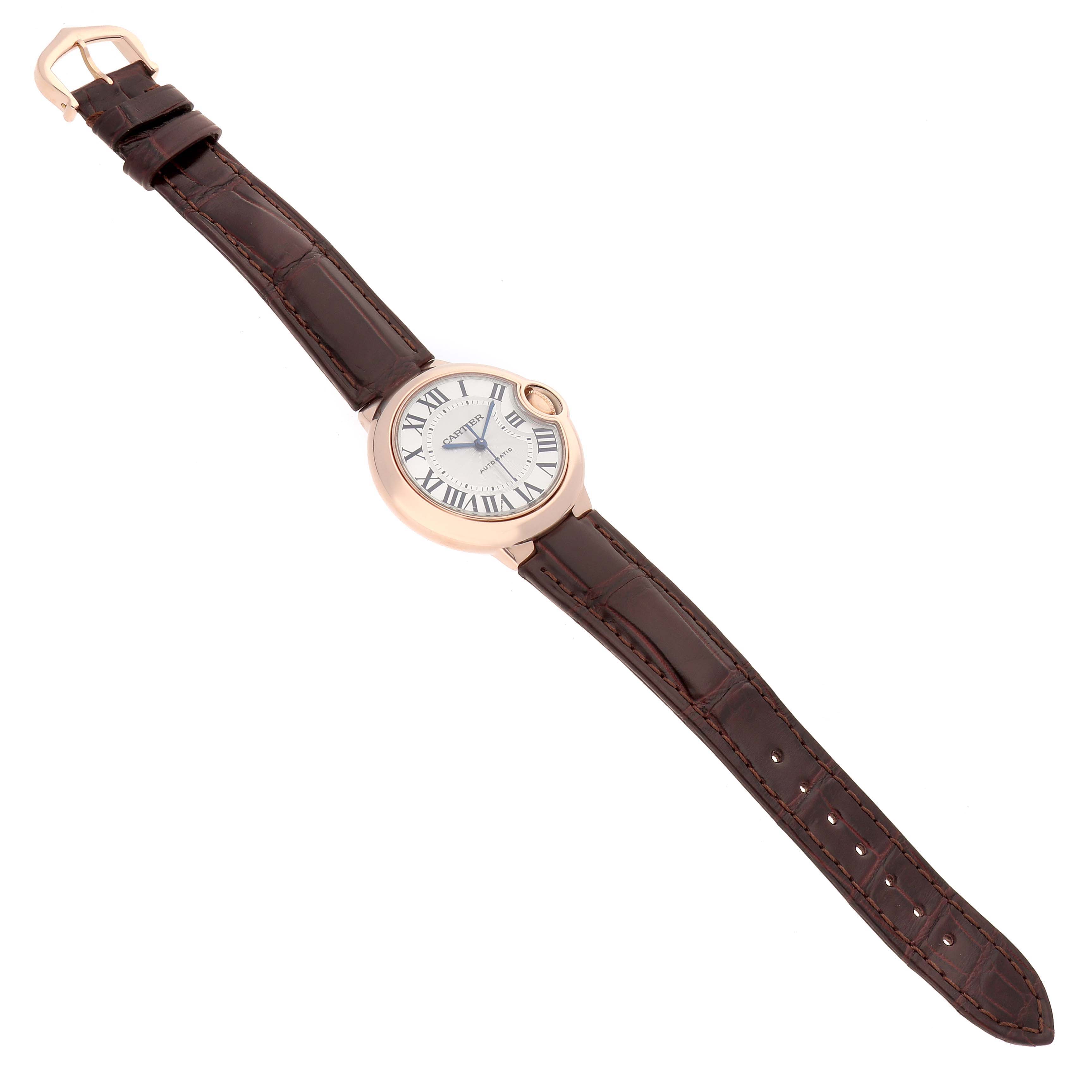 The Cartier Ballon Bleu W6920097 Women's Rose Gold Silver Dial watch is shown from a top-down angle, displaying the face and brown leather strap.