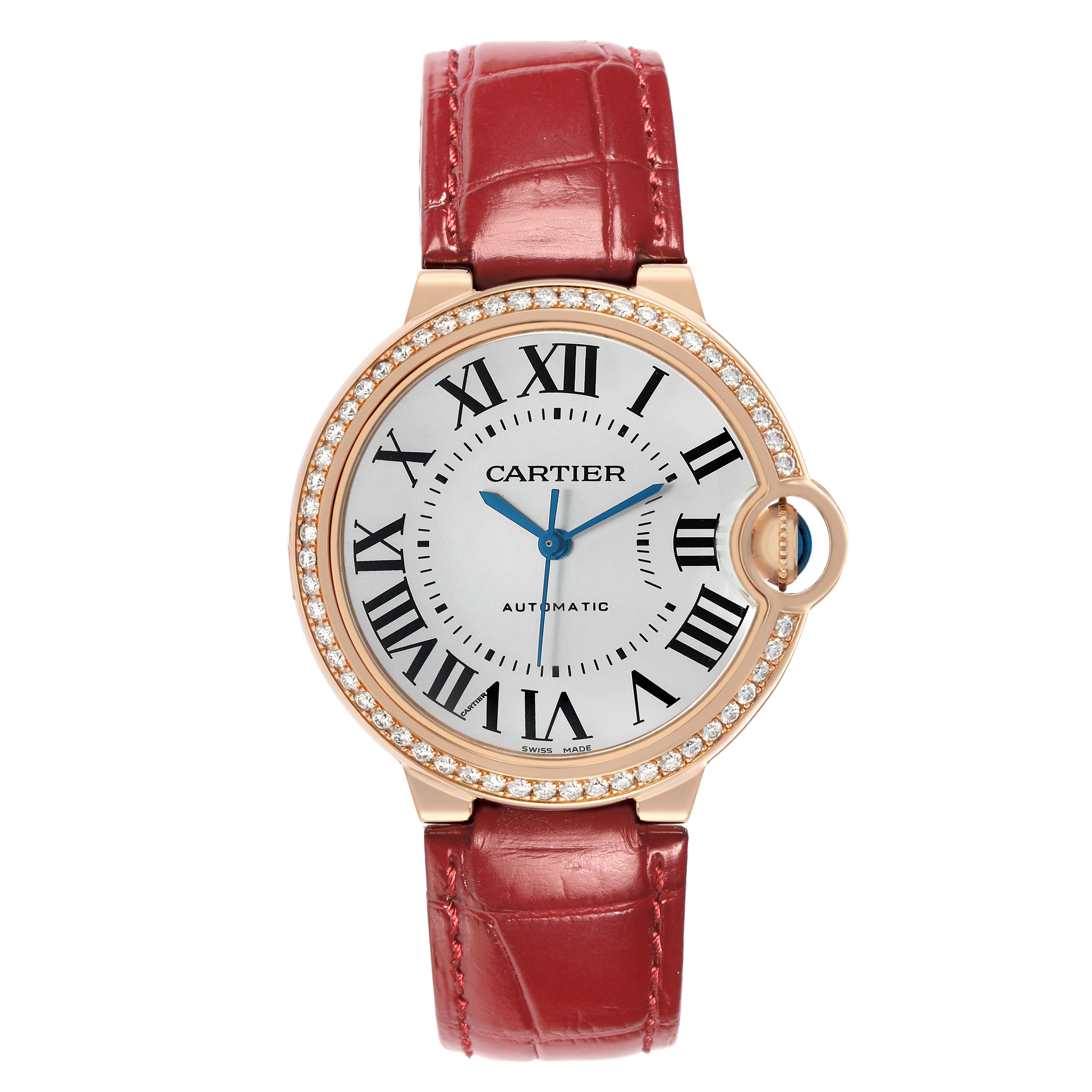 The Cartier Ballon Bleu WJBB0034 Women's Rose Gold Silver Dial watch is shown from the front, featuring a diamond bezel, Roman numerals, and a red leather strap.