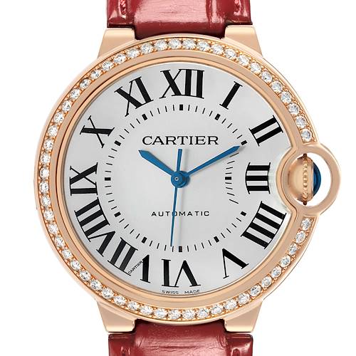 The image shows a frontal view of the Cartier Ballon Bleu WJBB0034 Women
s Rose Gold Silver Dial watch, highlighting its Roman numerals, blue hands, and diamond-set bezel.
