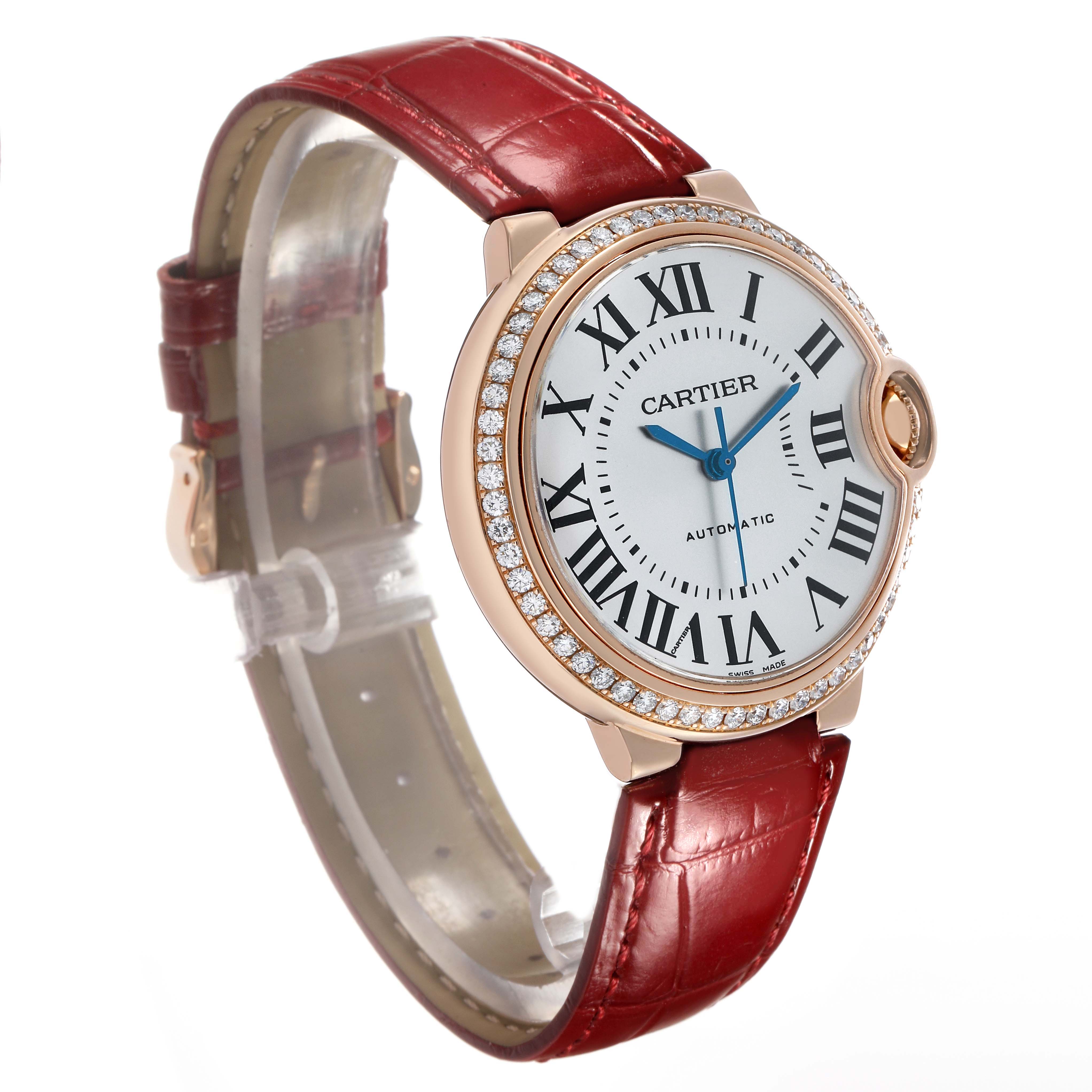 The Cartier Ballon Bleu WJBB0034 Women's Rose Gold Silver Dial watch is shown at a slight angle, highlighting the face, Roman numerals, and red leather strap.