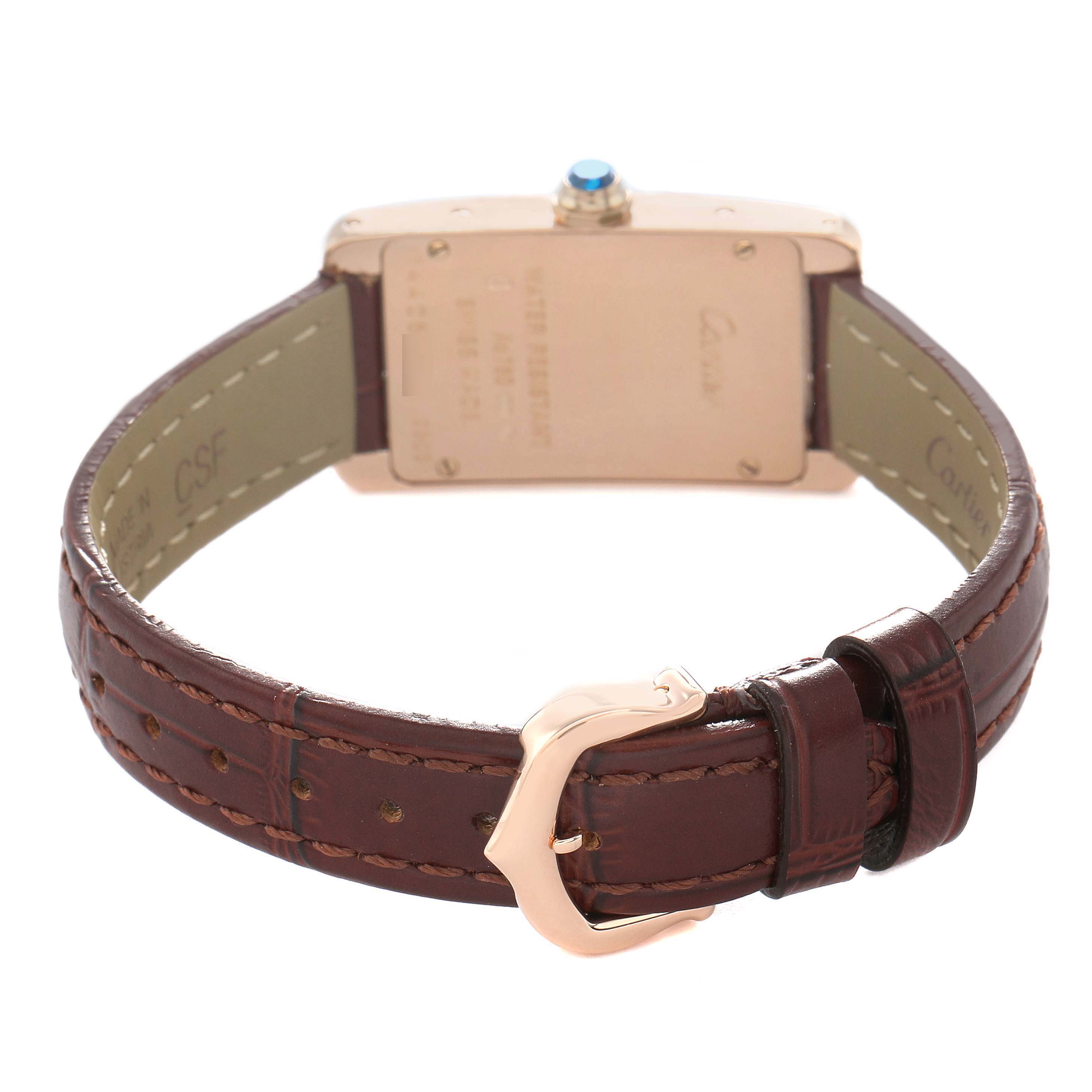 The Cartier Tank Americaine W2607456 Women's Rose Gold Silver Dial watch is shown from the back, highlighting the leather strap and clasp.