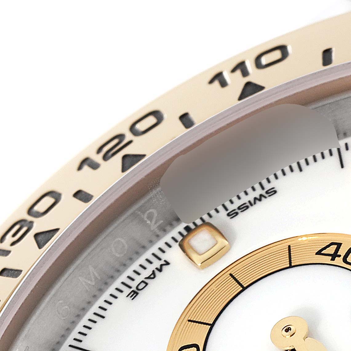 The image shows a close-up of the bezel and part of the dial of a Rolex Daytona 116503 Men's Steel and Gold (two tone) White Dial 116503 Men's Steel and Gold (two tone) White Dial watch.