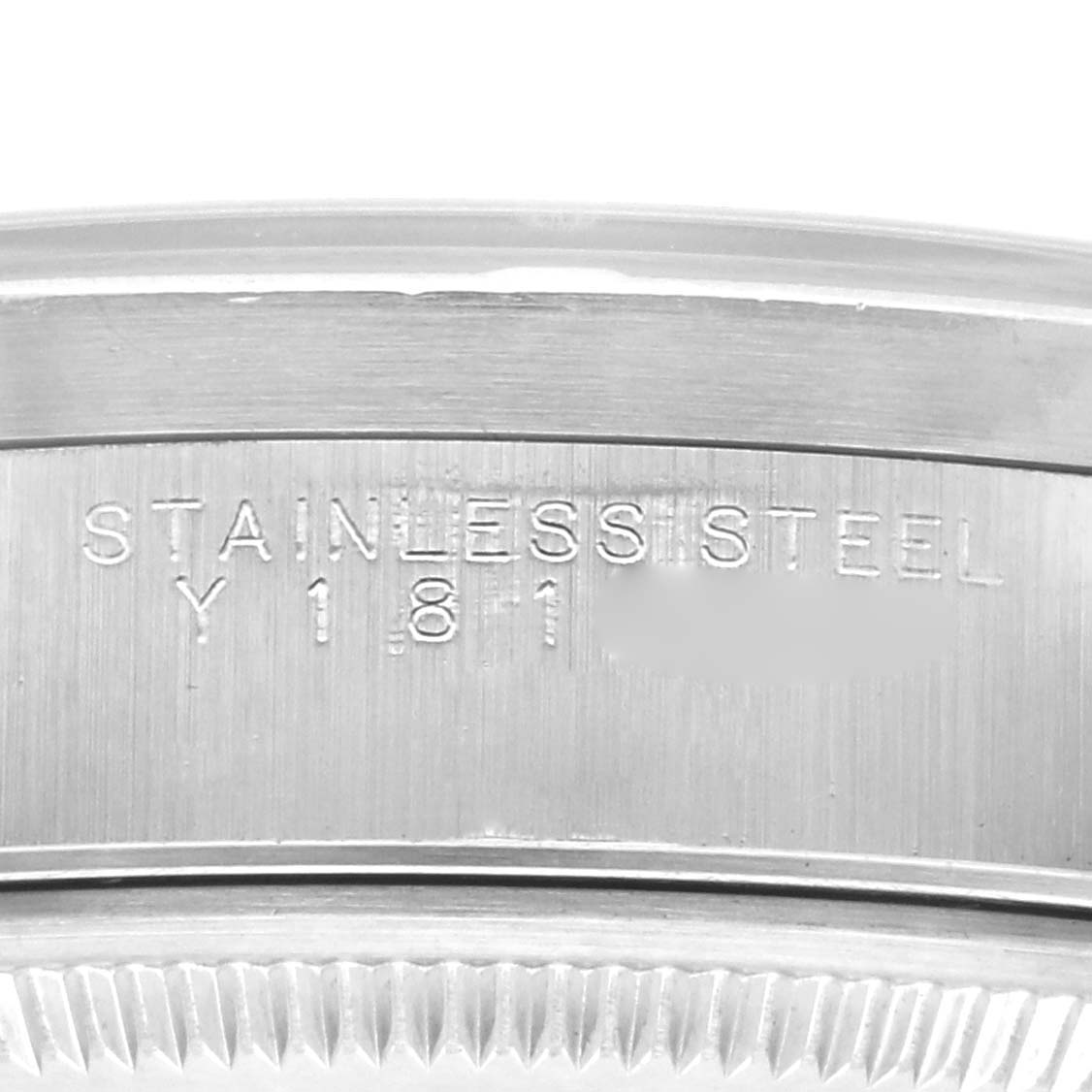 The image shows a close-up of the case band with engravings on a Rolex Date 15210 Men's Stainless Steel Blue Dial 15210 Men's Stainless Steel Blue Dial model, focusing on the stainless steel material.