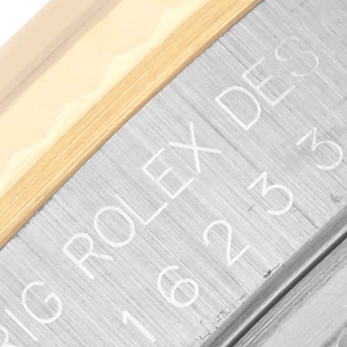 This close-up image of the Rolex Datejust 16233 Men's Steel and Gold (two tone) Silver Dial 16233 Men's Steel and Gold (two tone) Silver Dial shows the edge of the bezel with engraved text on the rehaut.