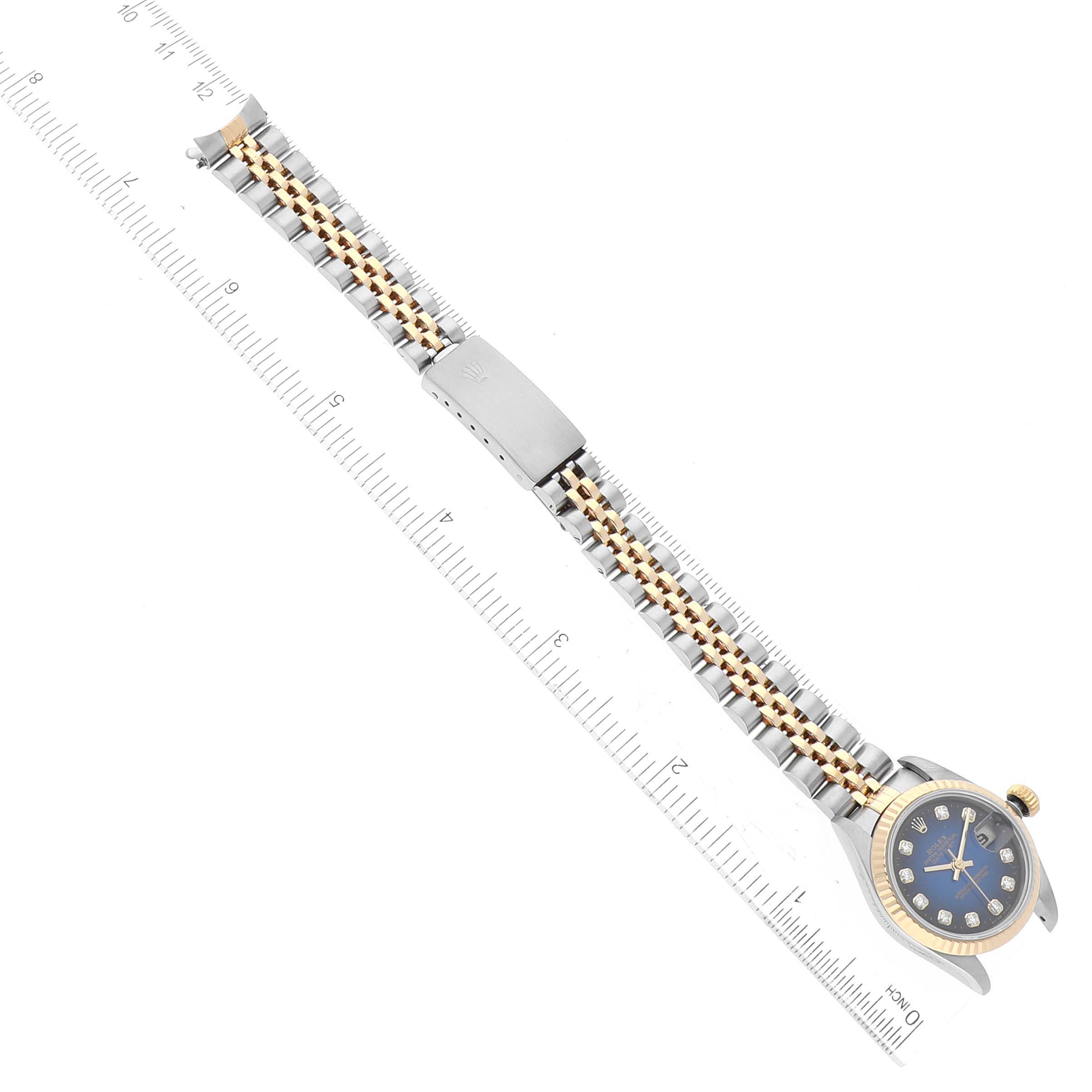 The Rolex Datejust 69173 Women's Steel and Gold (two tone) Blue Dial 69173 Women's Steel and Gold (two tone) Blue Dial watch is shown from an overhead angle, displaying its full length, dial, and two-tone bracelet with a ruler nearby.