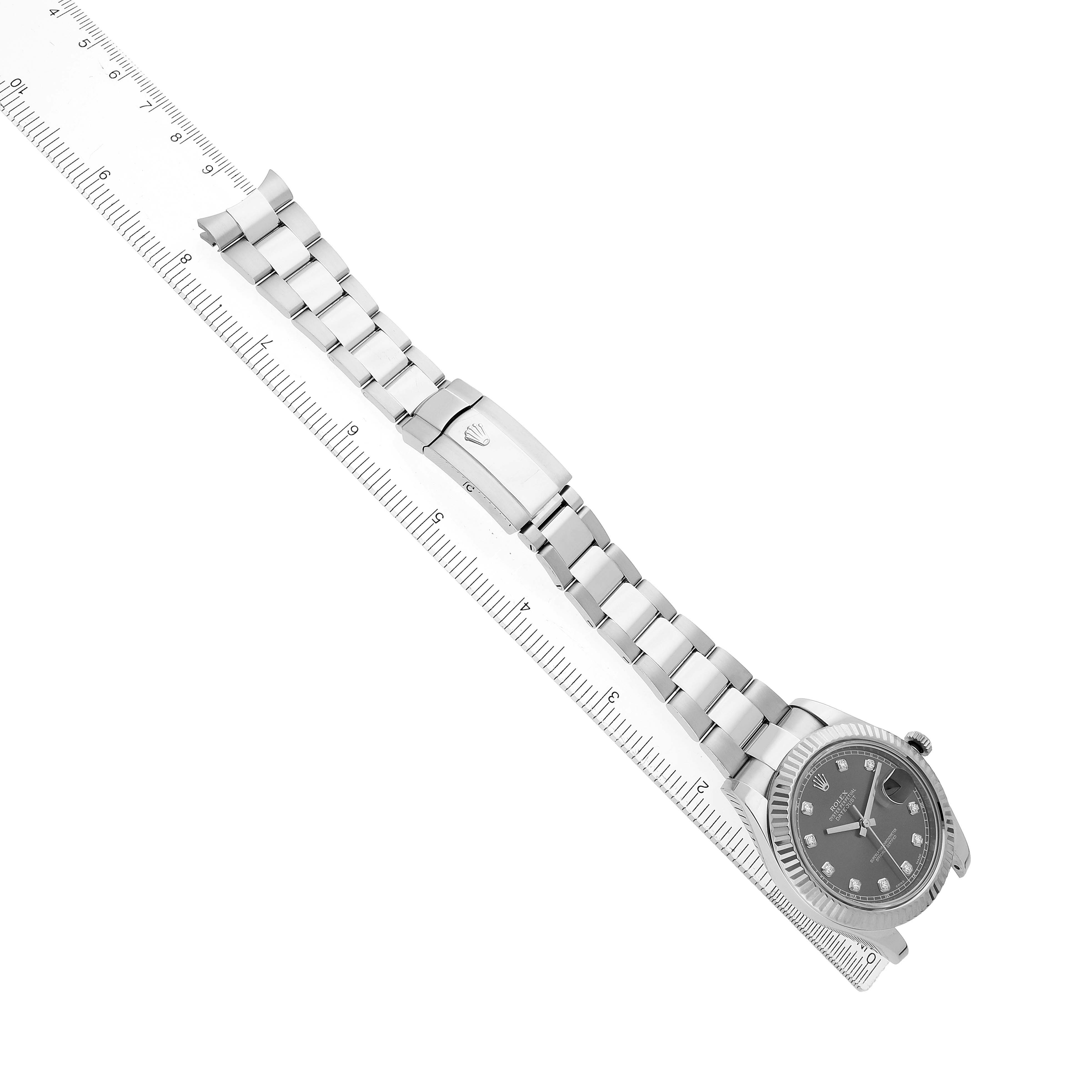 The Rolex Datejust 41 116334 Men's Stainless Steel Silver Dial is shown from a top-down angle, with its bracelet laid along a ruler for measurement.