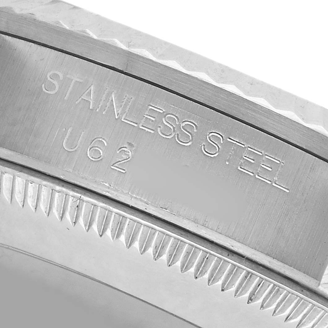 The image shows a close-up of the stainless steel bezel of a Rolex Mid-Size 68274 Women's Stainless Steel Silver Dial watch, highlighting its engraving and edge texture.