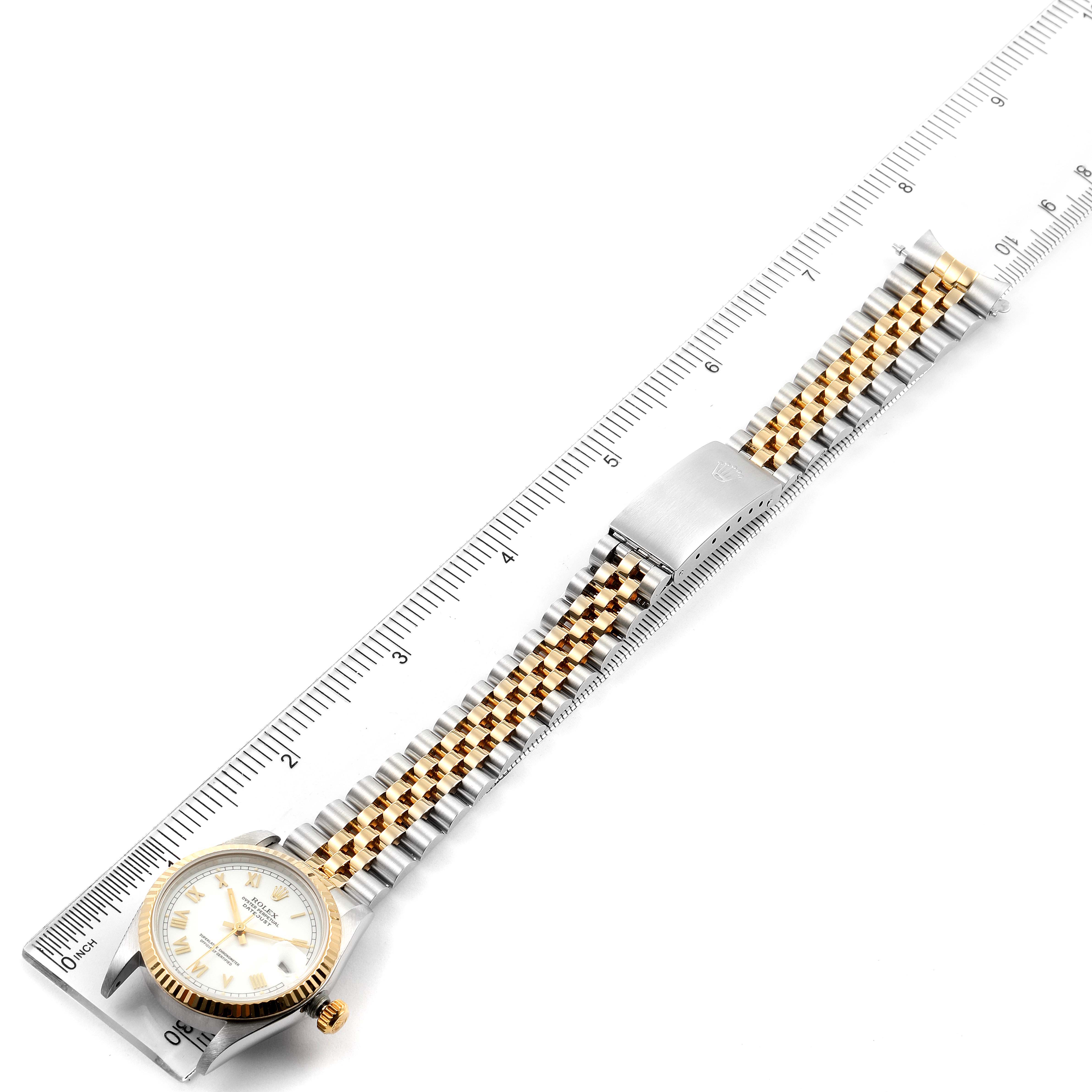 The Rolex Mid-Size 68273 Women's Steel and Gold (two tone) White Dial 68273 Women's Steel and Gold (two tone) White Dial model watch is shown laid flat from a top-down angle, with its bracelet fully extended and a ruler beside it.
