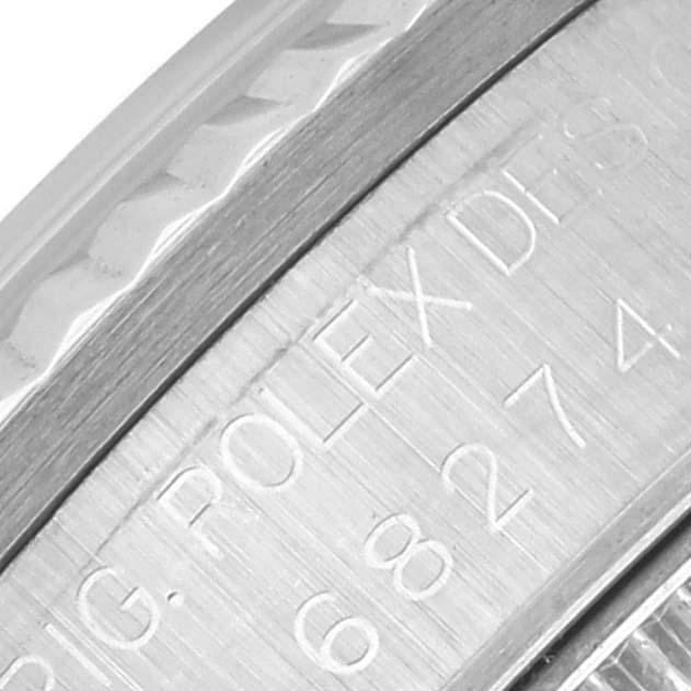 The image shows a close-up of the side detailing on a Rolex Mid-Size 68274 Women's Stainless Steel Silver Dial 68274 Women's Stainless Steel Silver Dial watch, focusing on engraved text.