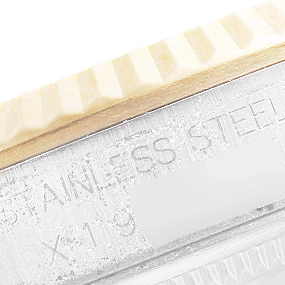 This image shows a close-up of the fluted bezel and engraved side panel of a Rolex Datejust 16233 Men's Steel and Gold (two tone) Champagne Dial 16233 Men's Steel and Gold (two tone) Champagne Dial watch.