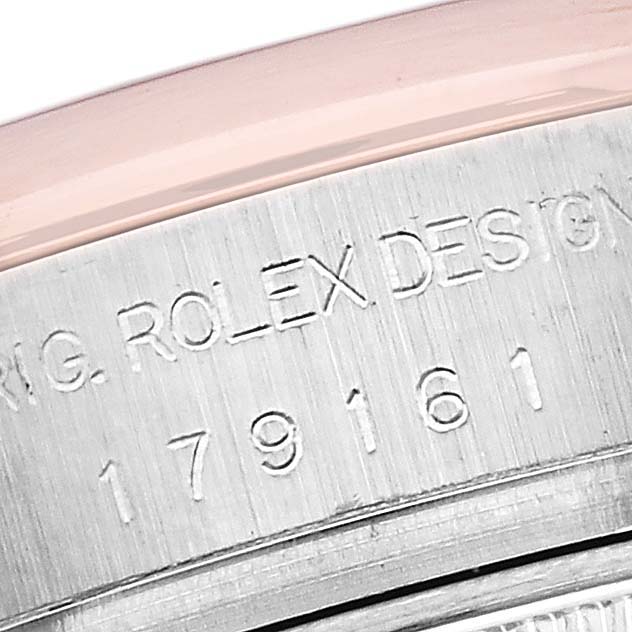 The image shows a close-up of the Rolex Datejust 179161 Women's Steel and Gold (two tone) Black Dial 179161 Women's Steel and Gold (two tone) Black Dial's engraved serial number and design markings on the case.