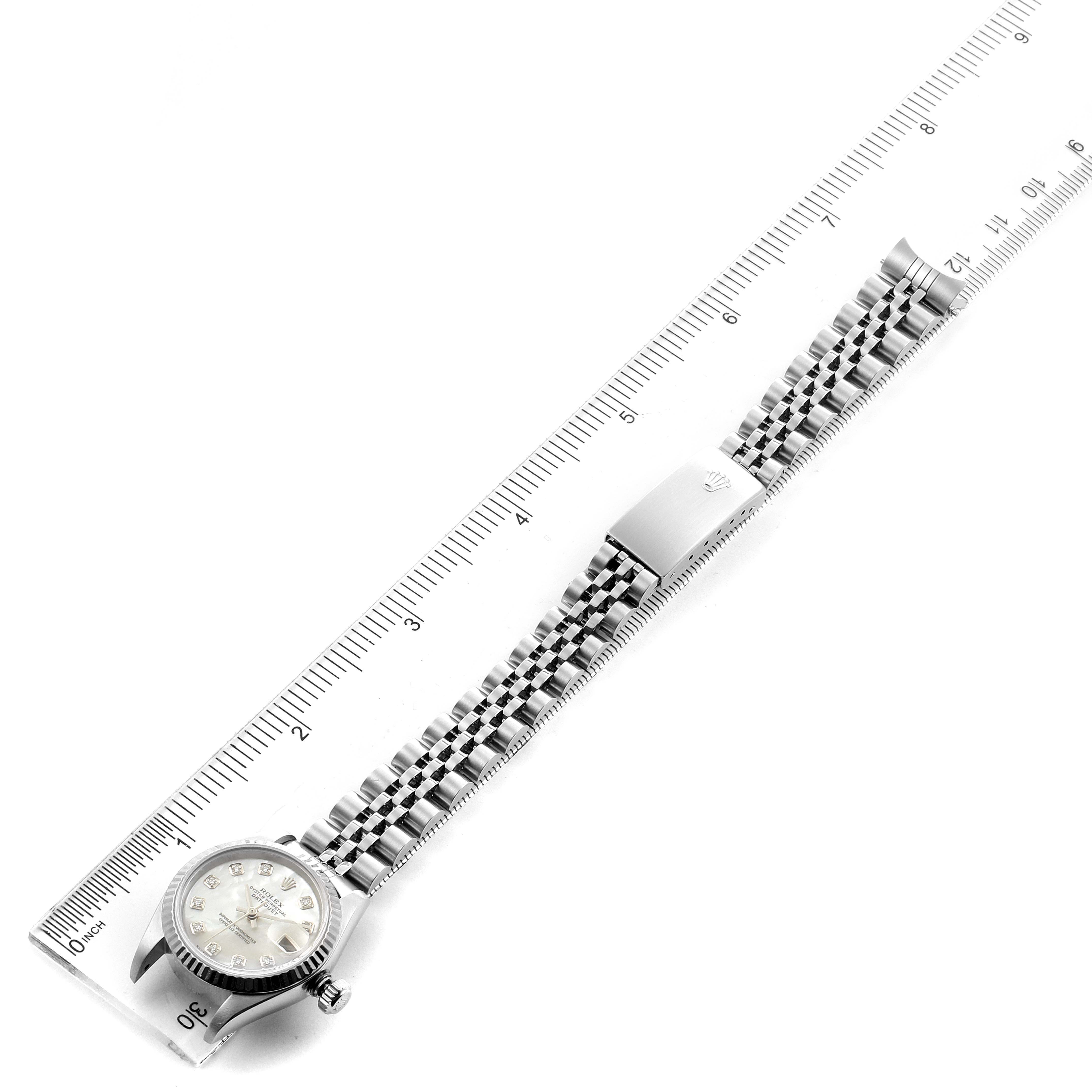 The image shows a top-down angle of a Rolex Datejust 79174 Women's Stainless Steel Mother of Pearl Dial 79174 Women's Stainless Steel Mother of Pearl Dial watch with the band extended alongside a ruler.