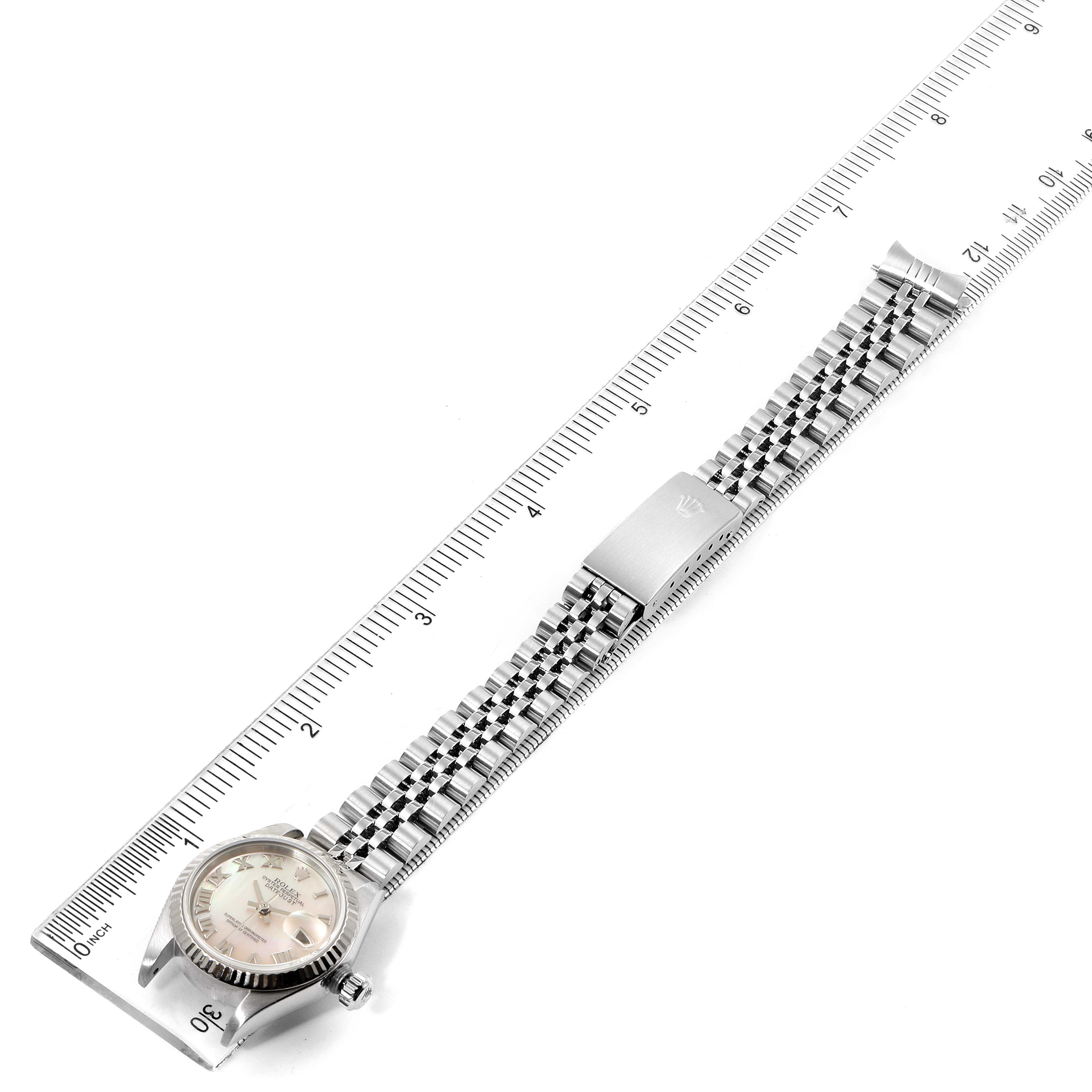 This image shows the Rolex Datejust 79174 Women's Stainless Steel Mother of Pearl Dial 79174 Women's Stainless Steel Mother of Pearl Dial watch laid flat alongside a measuring ruler, highlighting its strap and face.