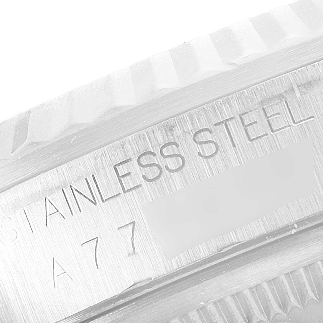 This close-up image shows the stainless steel fluted bezel and part of the casing with an engraving on a Rolex Datejust 16234 Men's Stainless Steel Silver Dial 16234 Men's Stainless Steel Silver Dial watch.