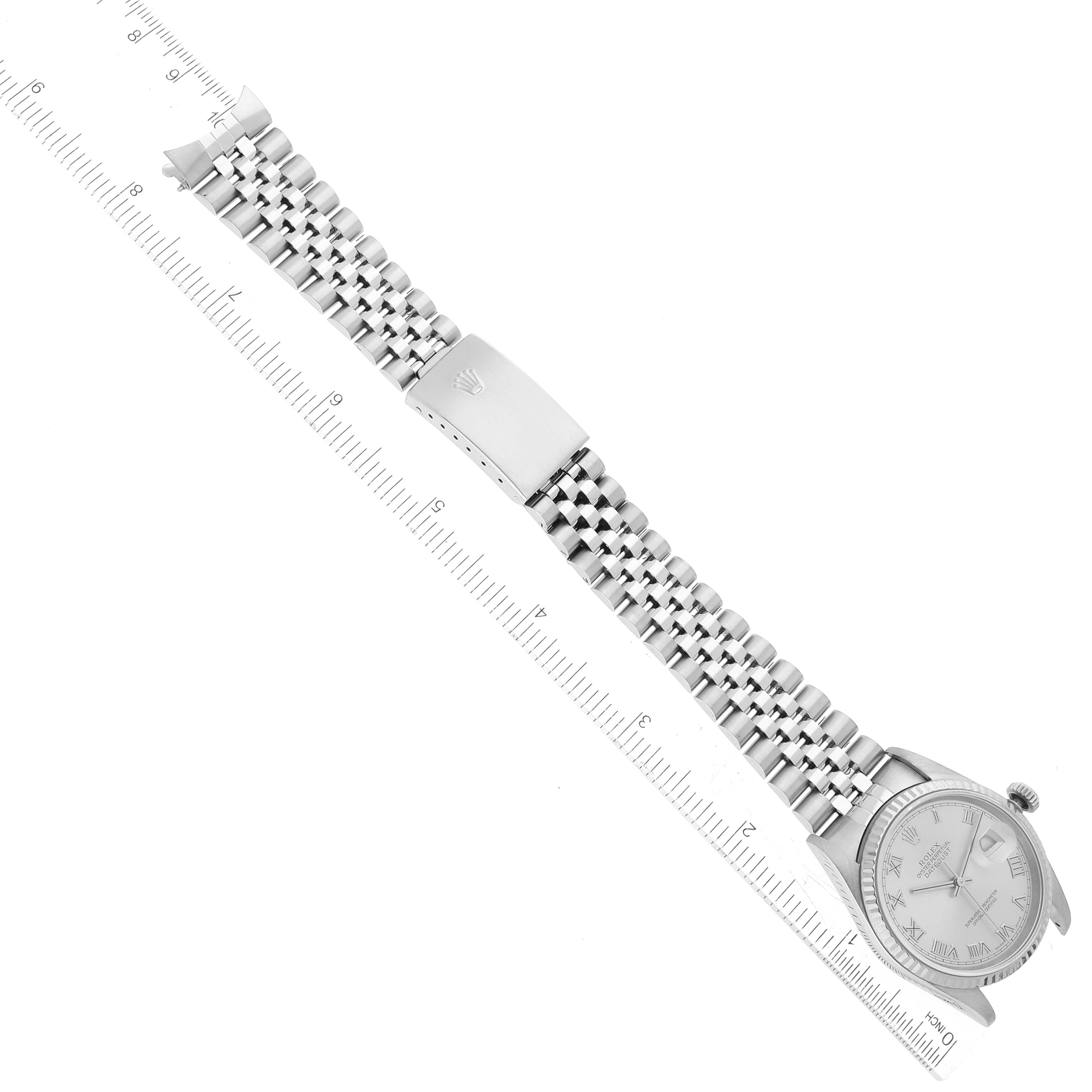 The image shows an overhead view of a Rolex Datejust 16234 Men's Stainless Steel Silver Dial 16234 Men's Stainless Steel Silver Dial watch, displaying the face, Jubilee bracelet, and closed clasp beside a ruler.