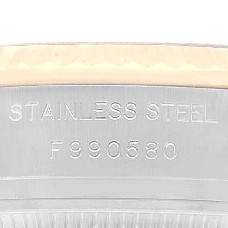 This image shows a close-up of the side of a Rolex Datejust 179173 Women's Steel and Gold (two tone) Silver Dial 179173 Women's Steel and Gold (two tone) Silver Dial watch, highlighting the "Stainless Steel" engraving and fluted bezel.