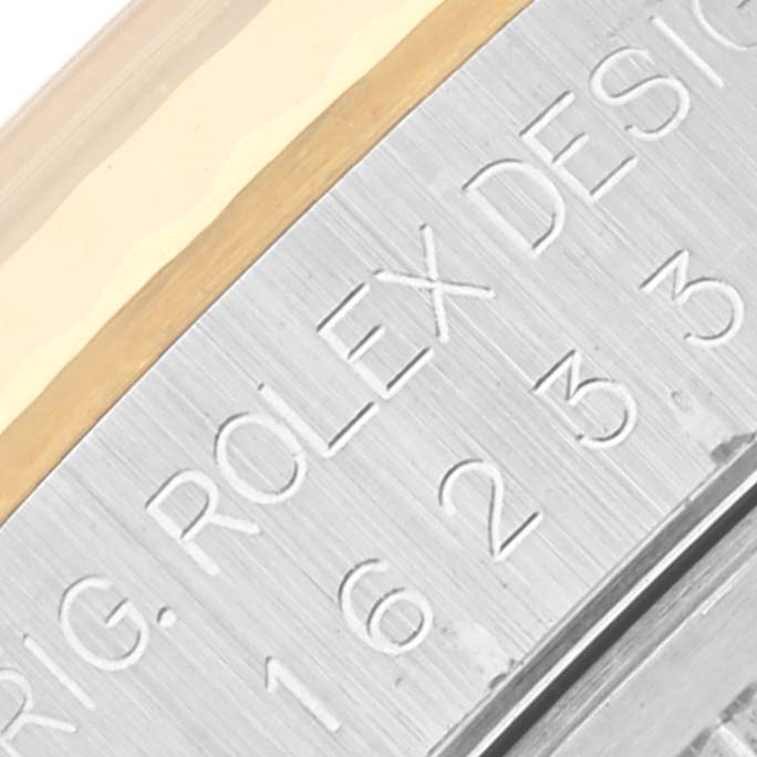 The image shows a close-up of the Rolex Datejust 16233 Men's Steel and Gold (two tone) Black Dial 16233 Men's Steel and Gold (two tone) Black Dial's engraved watch casing design details.