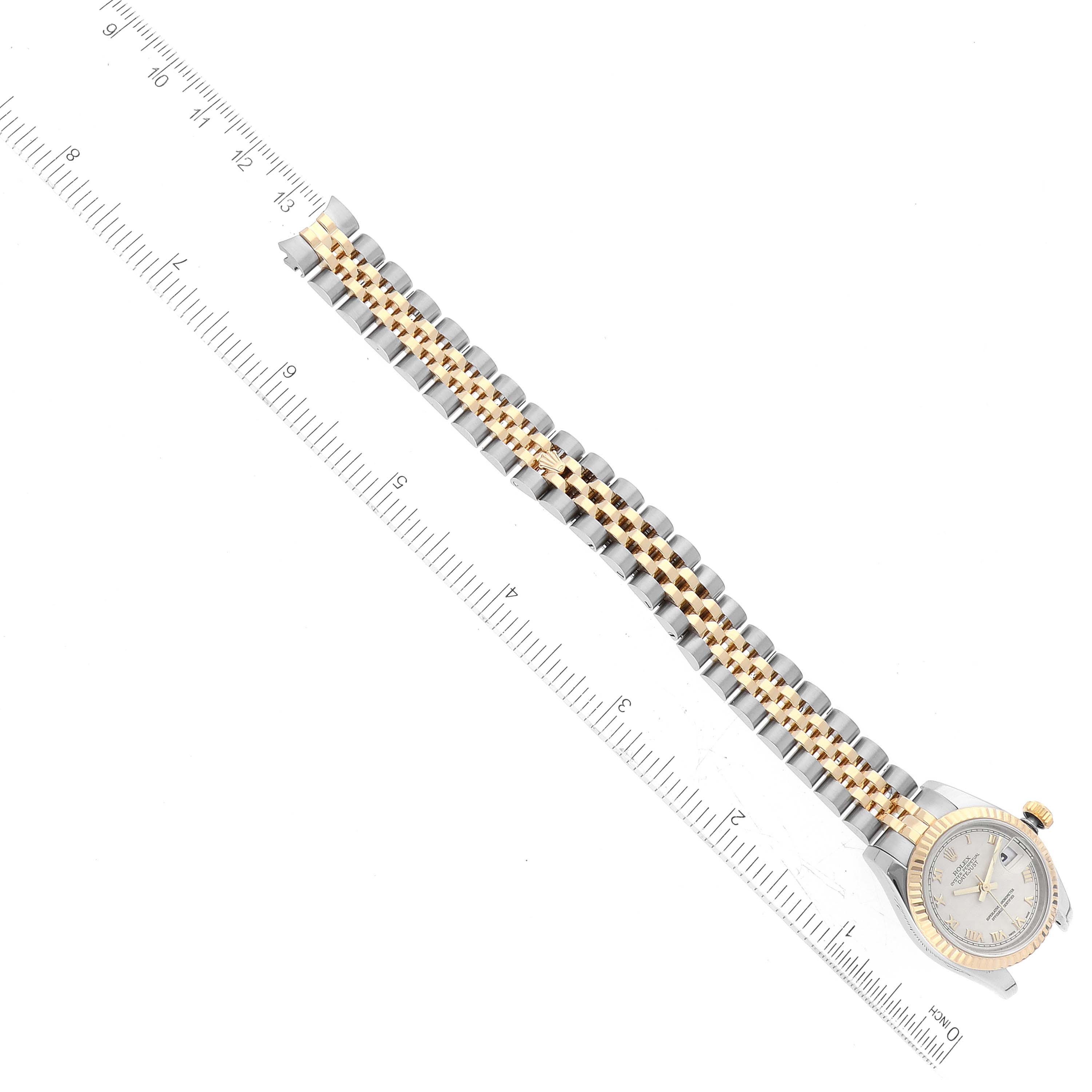 The image shows a Rolex Datejust 179173 Women's Steel and Gold (two tone) Beige Dial 179173 Women's Steel and Gold (two tone) Beige Dial watch from a top-down angle with the face and full bracelet visible, alongside a ruler for scale.