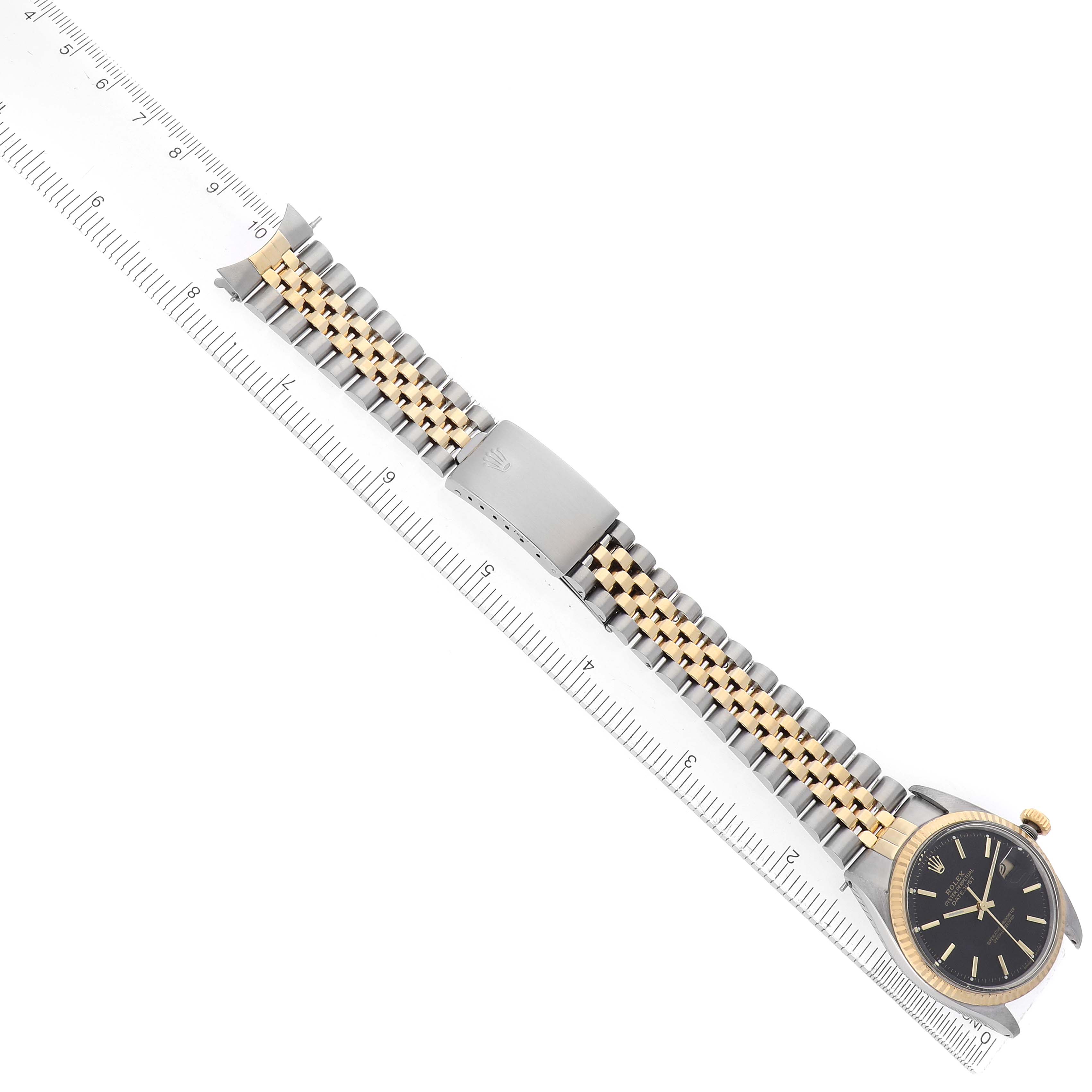 The image shows the Rolex Datejust 16013 Men's Steel and Gold (two tone) Black Dial model laid flat alongside a ruler, displaying the bracelet, clasp, and watch face at an angle.