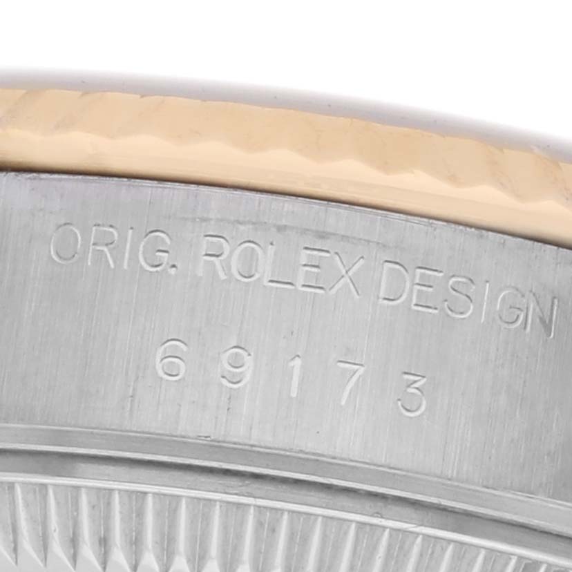 The image shows a close-up of the Rolex Datejust 69173 Women's Steel and Gold (two tone) White Dial model's side, highlighting the "ORIG. ROLEX DESIGN" engraving and reference number.