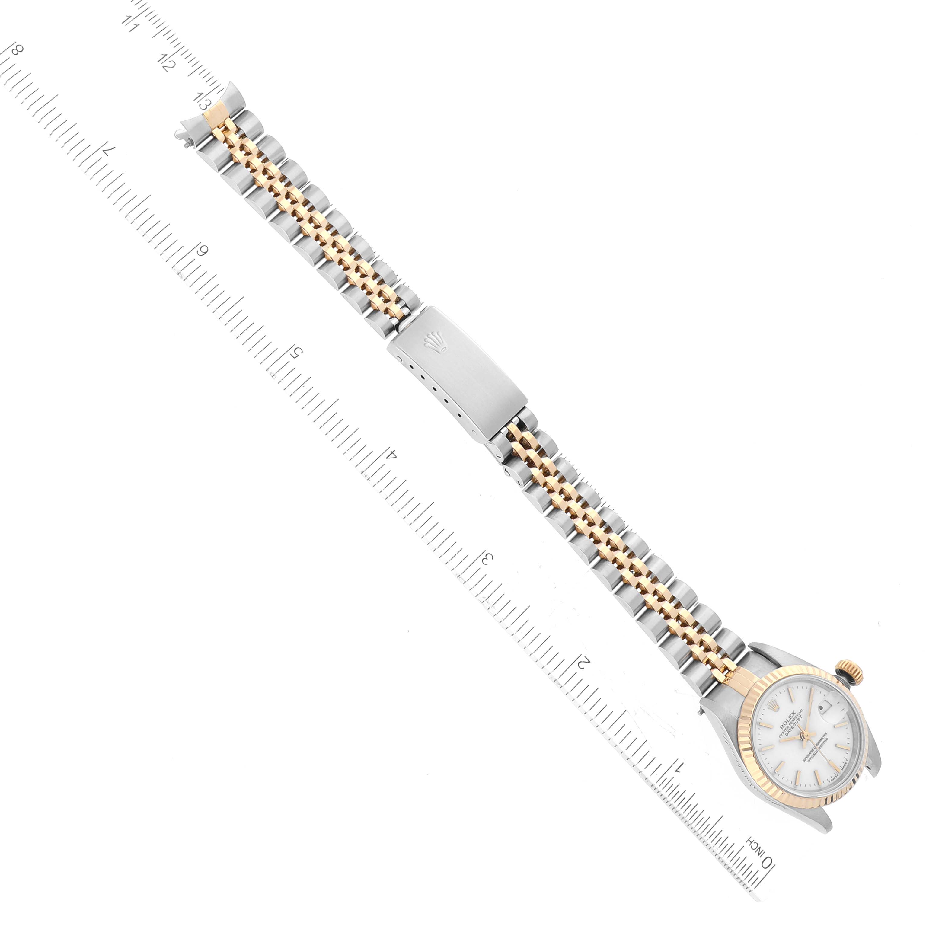 The image shows a top-down view of a Rolex Datejust 69173 Women's Steel and Gold (two tone) White Dial 69173 Women's Steel and Gold (two tone) White Dial watch with a two-tone metal bracelet and ruler measurements.
