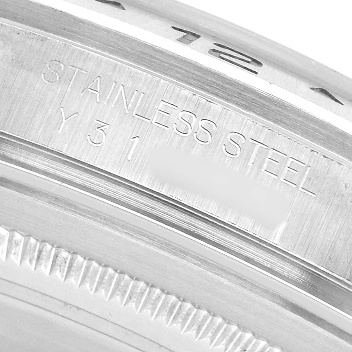 The image shows a close-up of the inner bezel and outer rim of a Rolex Explorer 16570 Men's Stainless Steel White Dial watch, displaying the "STAINLESS STEEL" engraving.