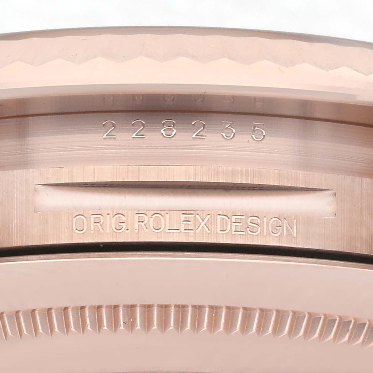 This image focuses on the edge of the bezel and the engraved case back of the Rolex President 228235-004 Men's Rose Gold Silver Dial 228235-004 Men's Rose Gold Silver Dial model.