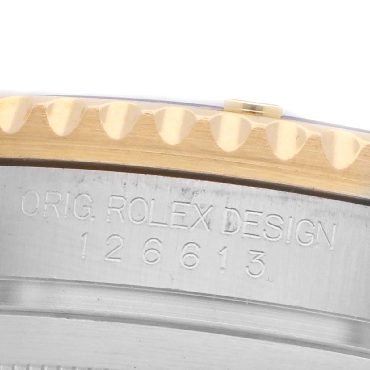 The image shows a close-up side angle of the Rolex Submariner 126613 Men's Steel and Gold (two tone) Blue Dial's bezel and engraved side case.