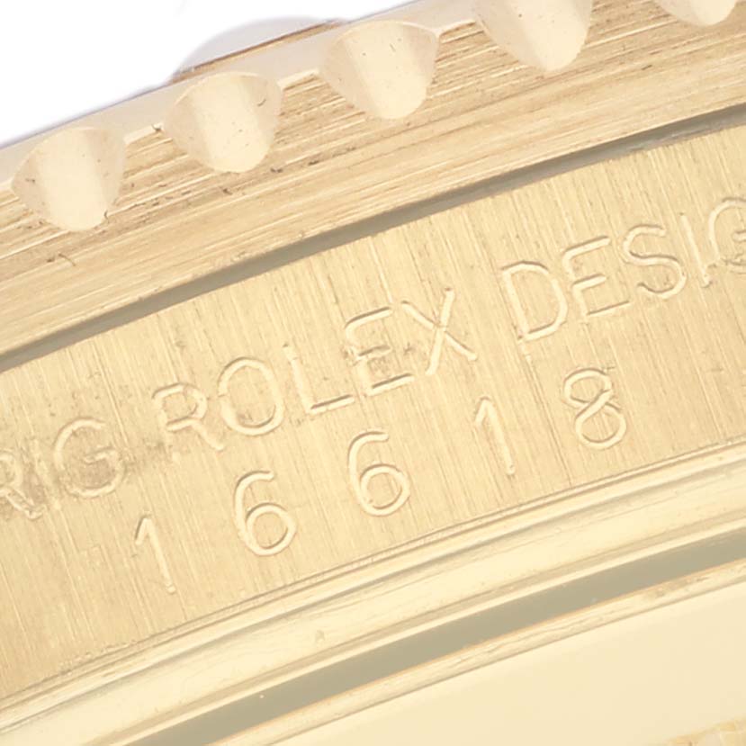 The image shows a close-up angle of the Rolex Submariner 16618 Men's Yellow Gold Blue Dial 16618 Men's Yellow Gold Blue Dial model's engraved bezel and case design detail.