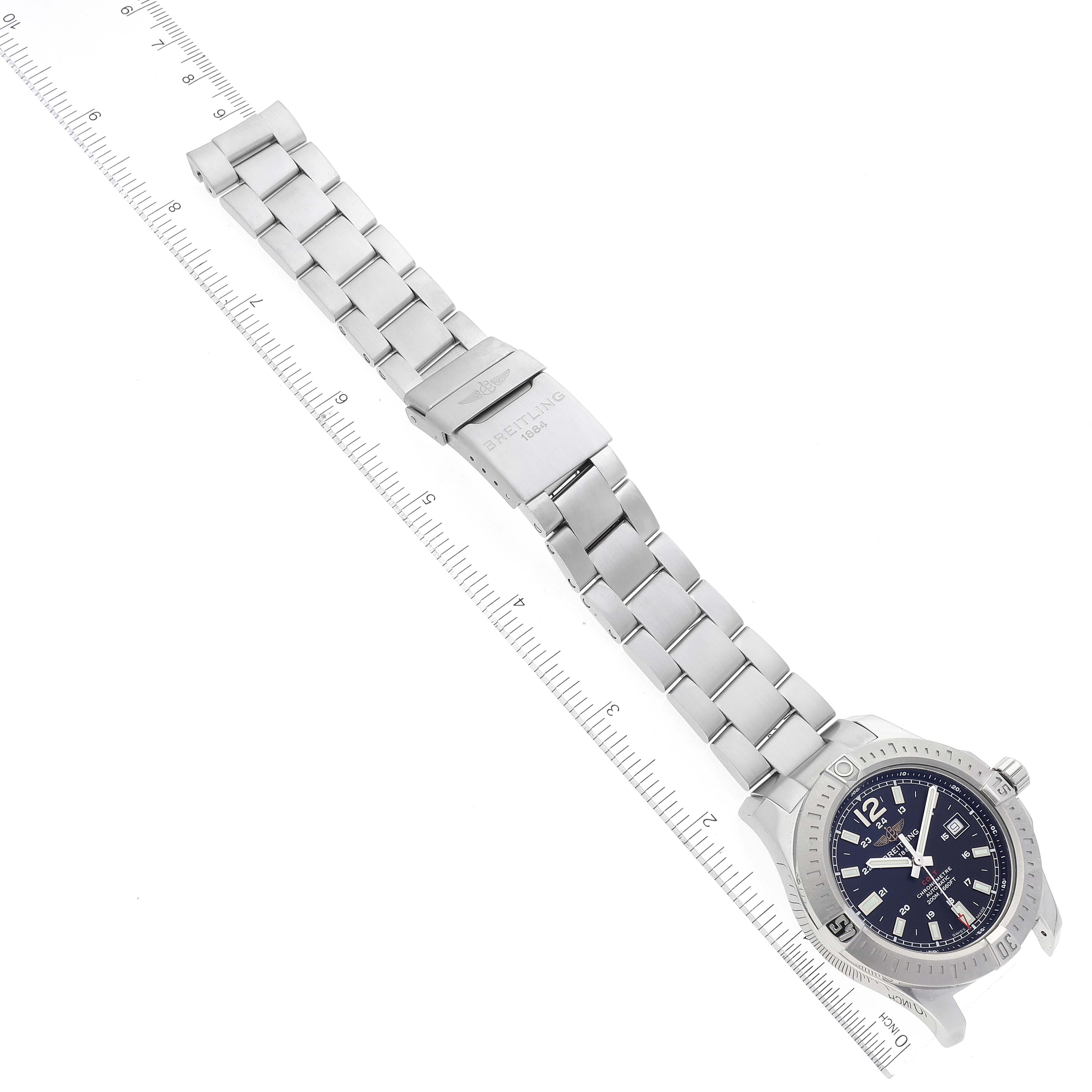 This image shows the Breitling Colt A17388 Men's Stainless Steel Black Dial A17388 Men's Stainless Steel Black Dial watch laid out flat, with its full metallic bracelet and clasp visible, alongside a ruler for scale.