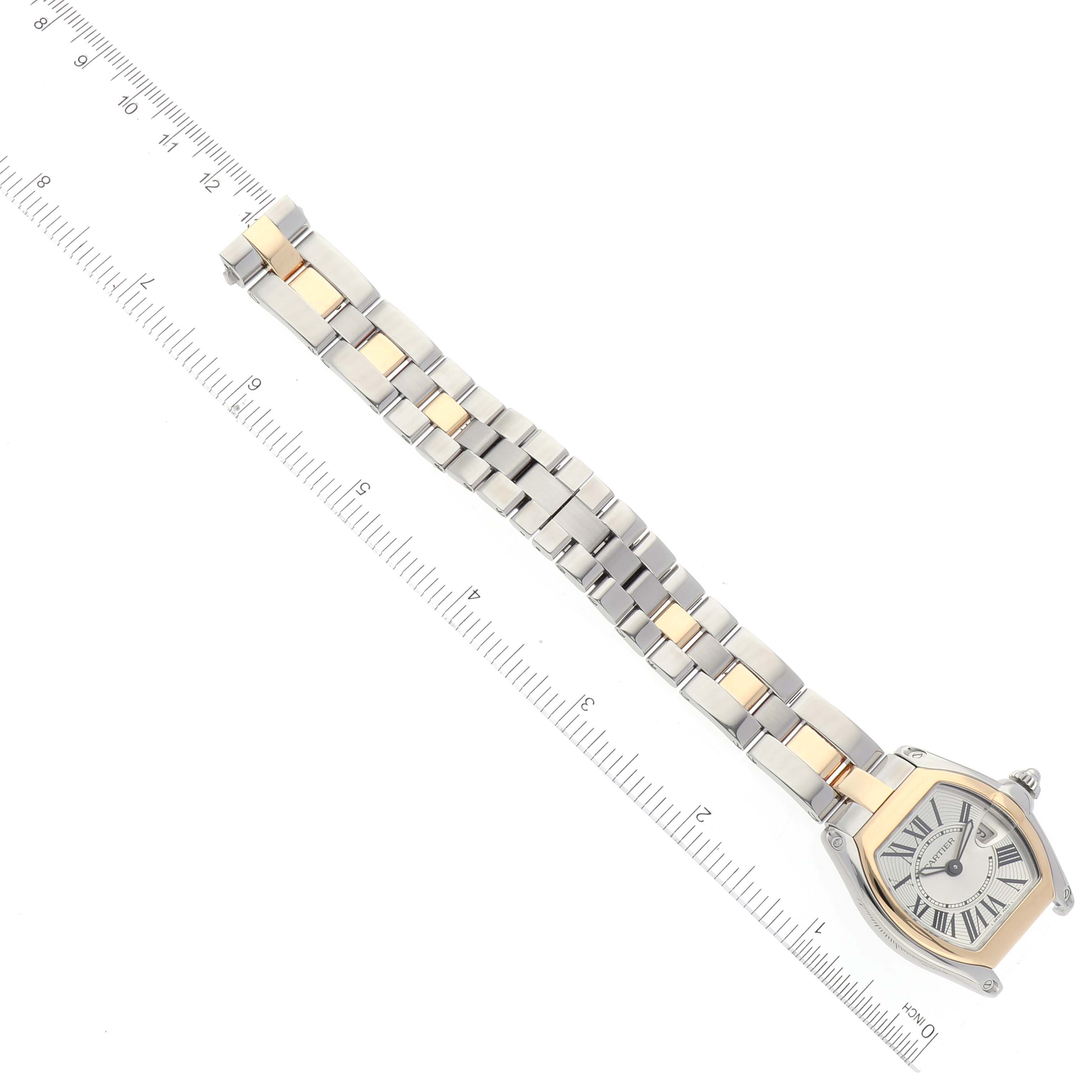 The image shows a Cartier Roadster W62026Y4 Women's Steel and Gold (two tone) Silver Dial W62026Y4 Women's Steel and Gold (two tone) Silver Dial watch laid flat with its bracelet fully extended, next to a ruler for scale.