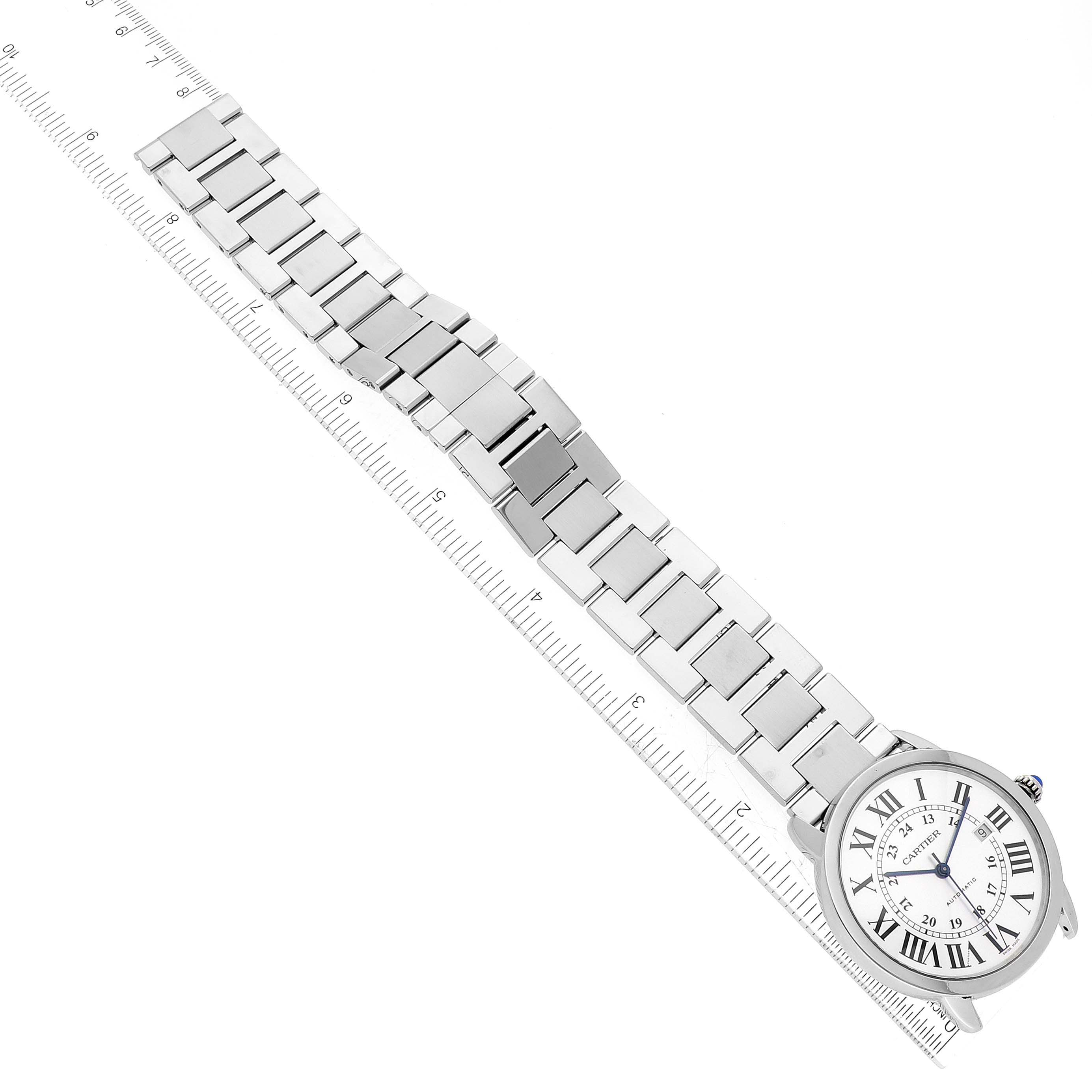 The image shows a top-down view of a Cartier Ronde W6701011 Men
s Stainless Steel Silver Dial W6701011 Men
s Stainless Steel Silver Dial model watch, displaying the face and metal bracelet alongside a ruler.