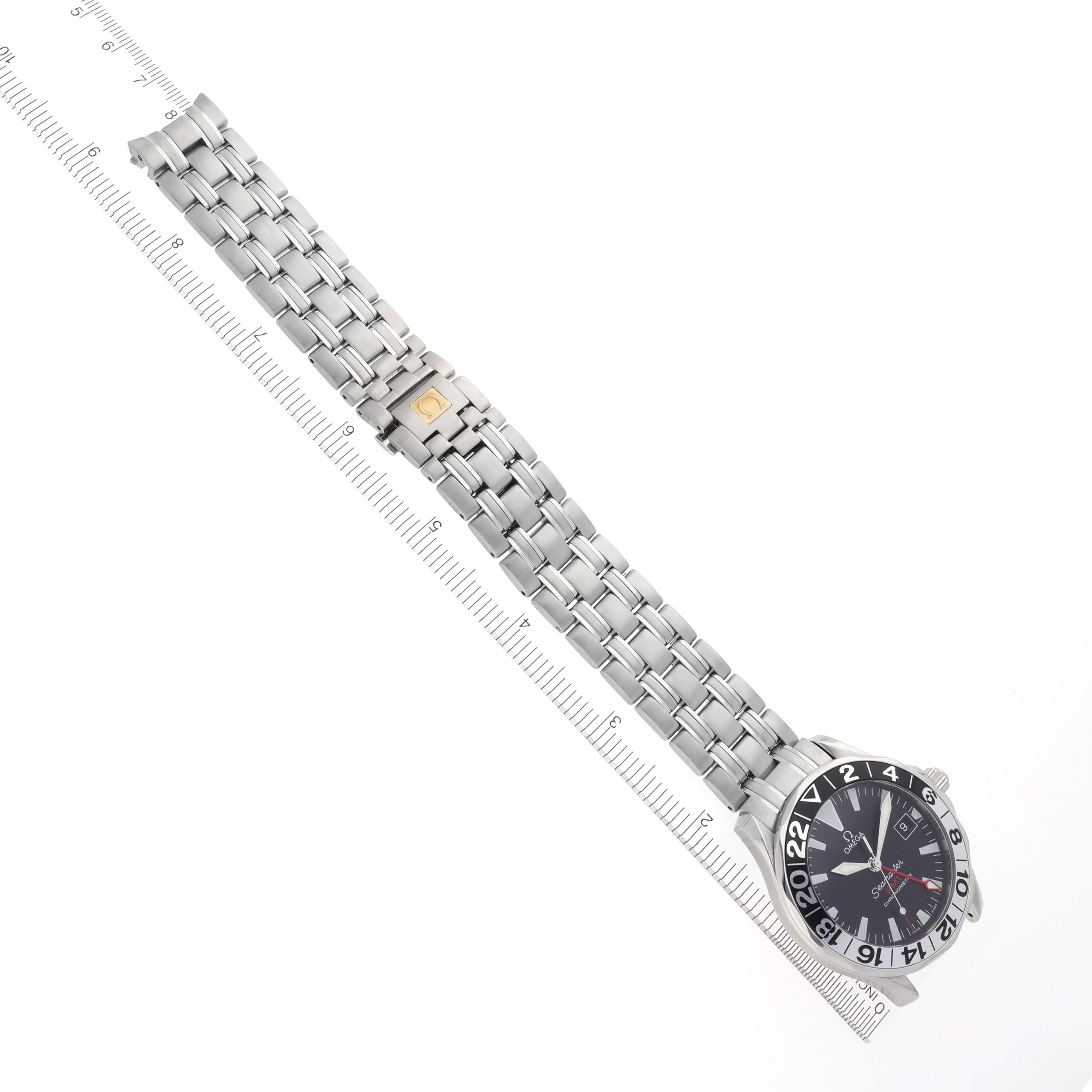 The Omega Seamaster 2234.50.00 Men
s Stainless Steel Black Dial 2234.50.00 Men
s Stainless Steel Black Dial watch is shown from a top view, displaying its face and metal bracelet alongside a ruler for scale.