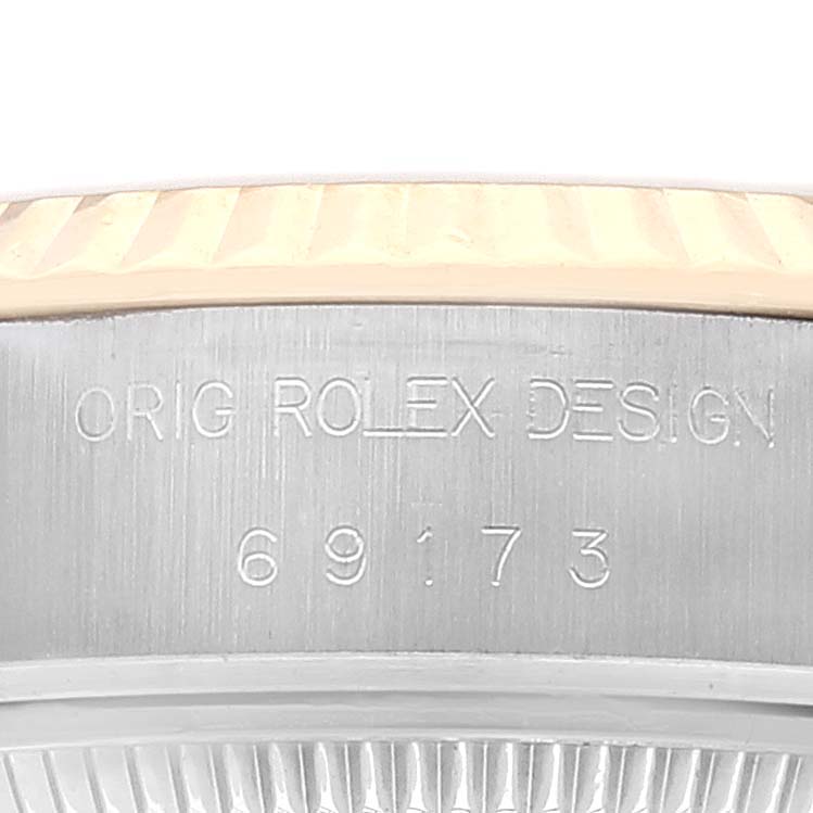 This image shows a close-up of the case side of a Rolex Datejust 69173 Women's Steel and Gold (two tone) Champagne Dial 69173 Women's Steel and Gold (two tone) Champagne Dial watch, displaying the inscription "ORIG ROLEX DESIGN 69173."