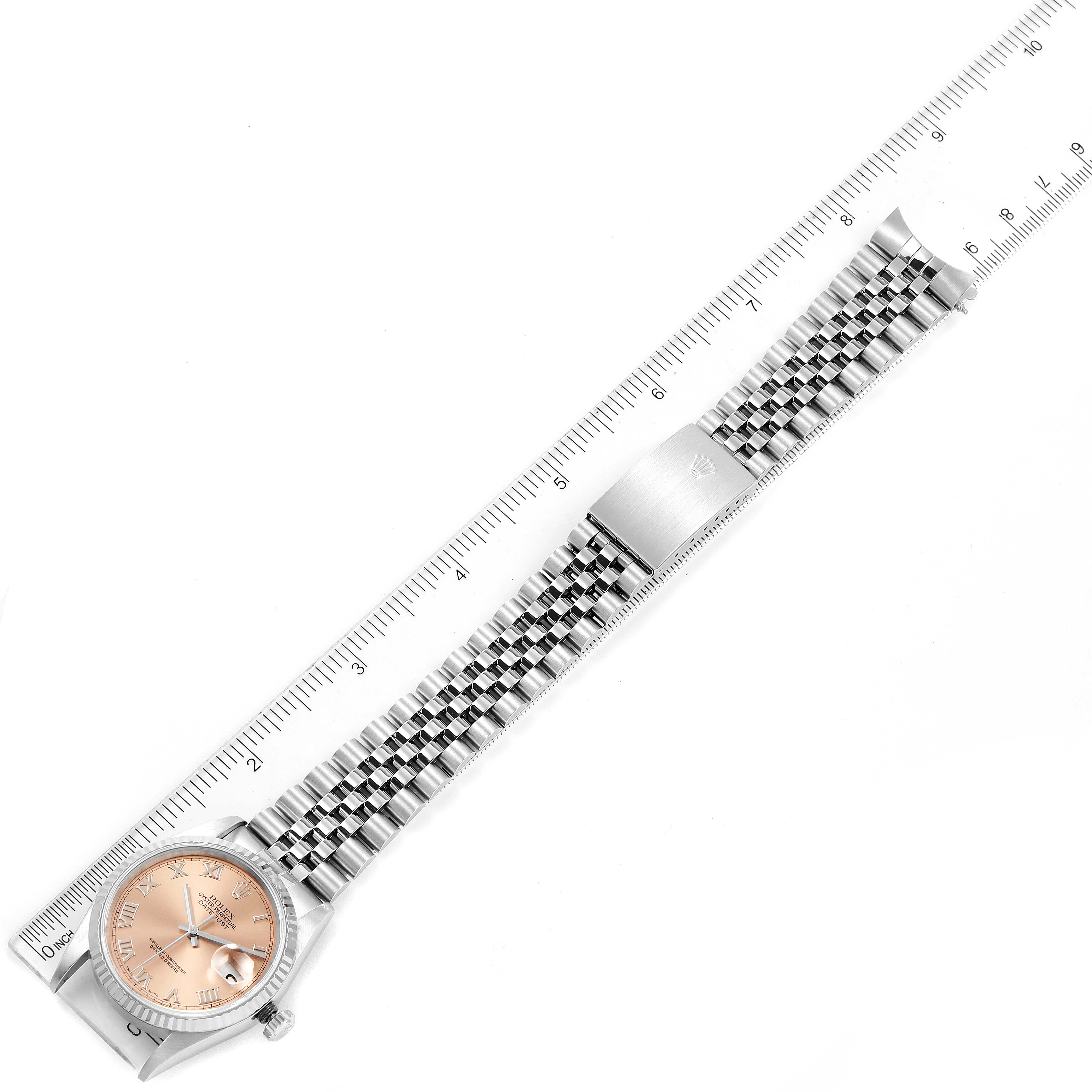 The Rolex Datejust 16234 Men
s Stainless Steel Pink Dial 16234 Men
s Stainless Steel Pink Dial watch is shown horizontally with its dial, bracelet, and clasp visible, aligned next to a ruler for scale.