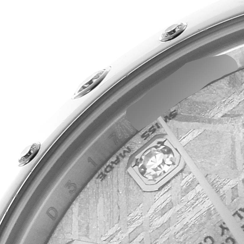 The image shows a close-up of the bezel and part of the dial on a Mid-Size Rolex watch, detailing screws and textures.