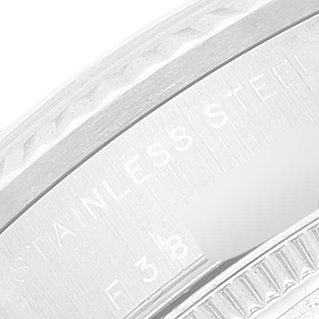 This image shows a close-up of the side and part of the bezel of a Mid-Size Rolex watch, highlighting the "STAINLESS STEEL" engraving.