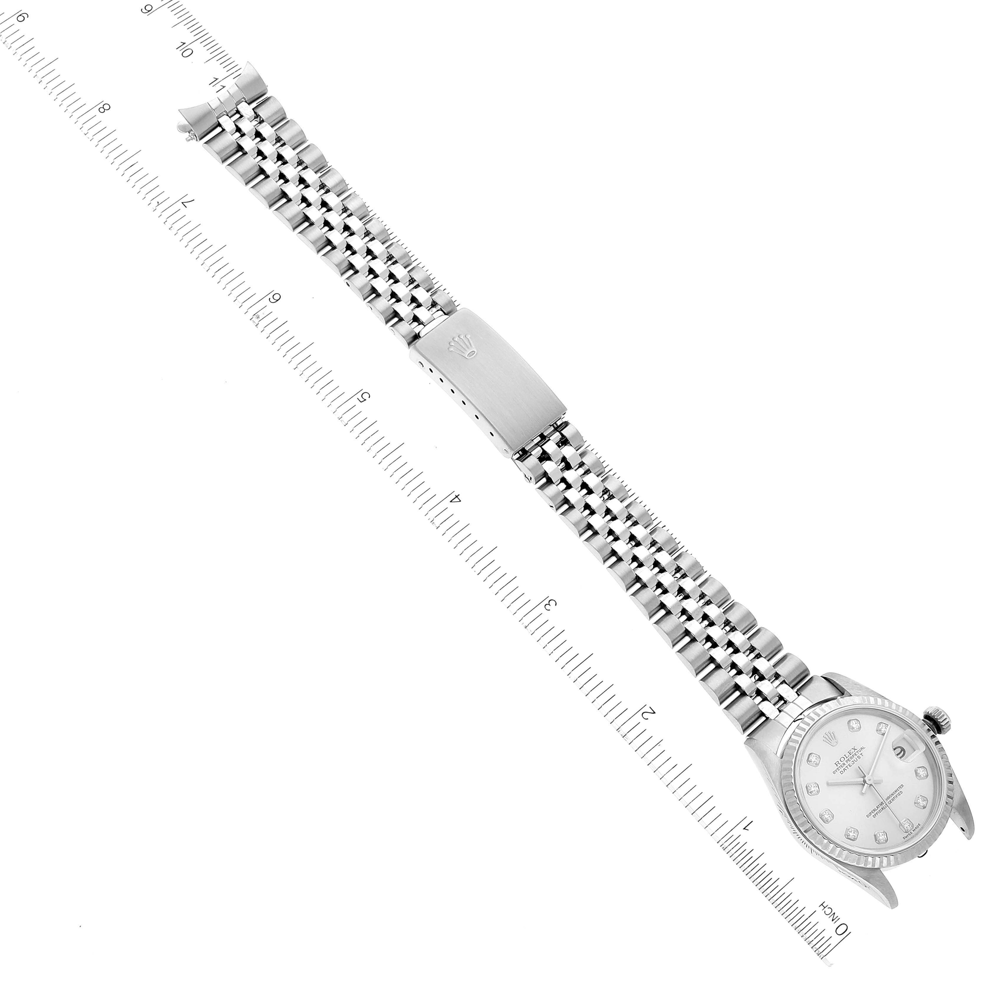 The image shows a top-down view of a Mid-Size Rolex watch, focusing on its face and metal bracelet with a ruler for scale.