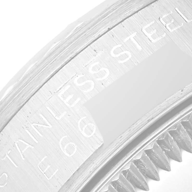 The image shows a close-up of the bezel and part of the case of a Rolex Mid-Size 68274 Women's Stainless Steel Silver Dial 68274 Women's Stainless Steel Silver Dial watch, highlighting the stainless steel engraving.