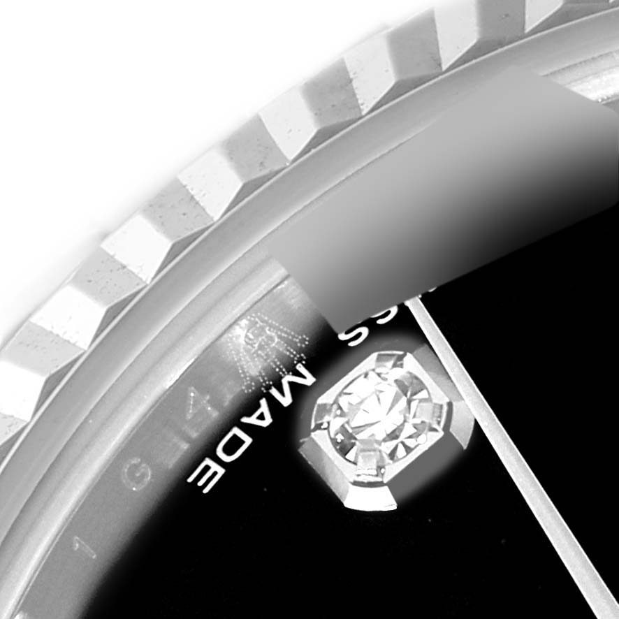 This close-up image of a Rolex Mid-Size 178274 Women
s Stainless Steel Black Dial 178274 Women
s Stainless Steel Black Dial model watch shows part of the bezel, dial with diamond marker, and 
Swiss Made
 text.
