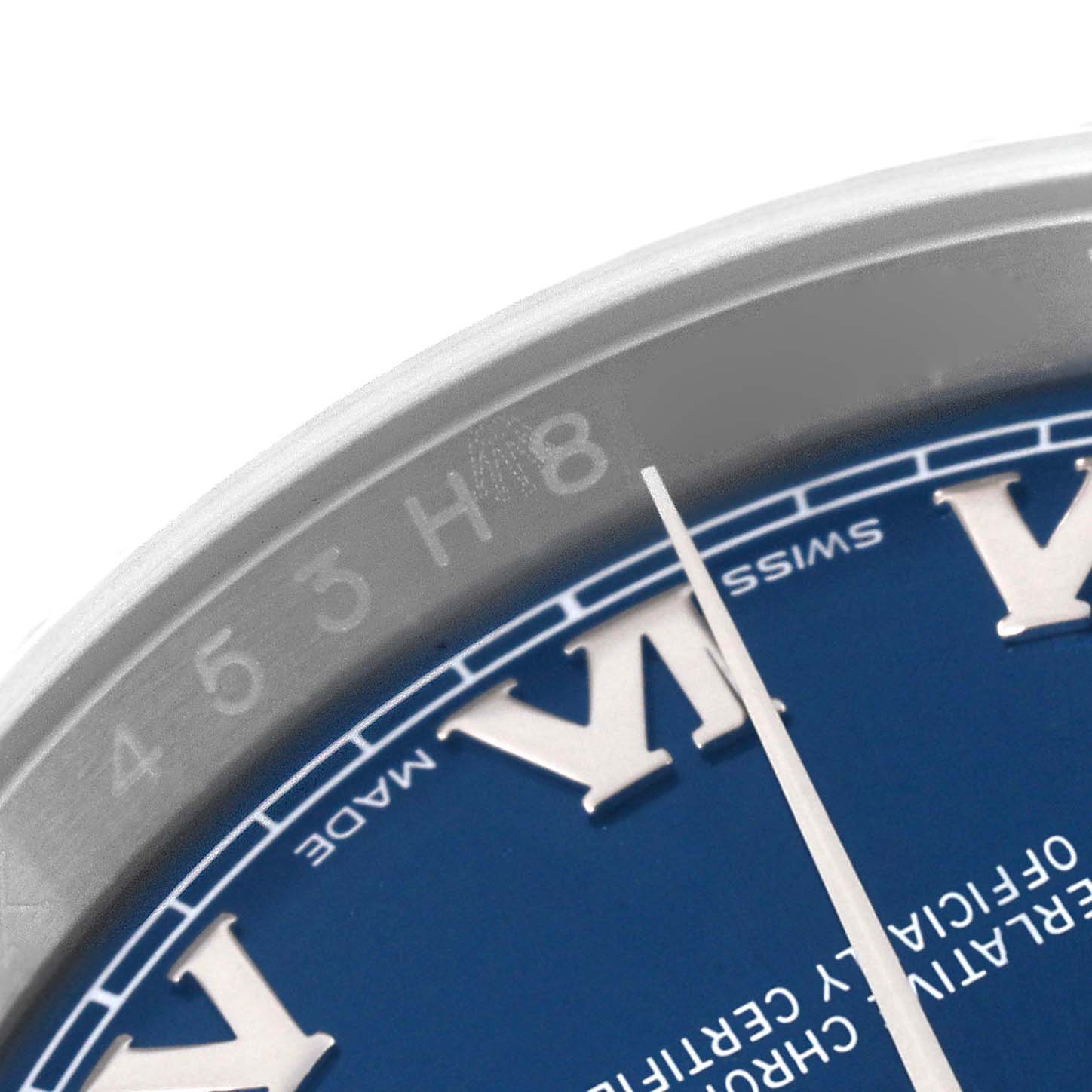 This close-up image shows part of the dial and the engraved rehaut of a Rolex Datejust 116234 Men's Stainless Steel Blue Dial 116234 Men's Stainless Steel Blue Dial watch with Roman numerals.