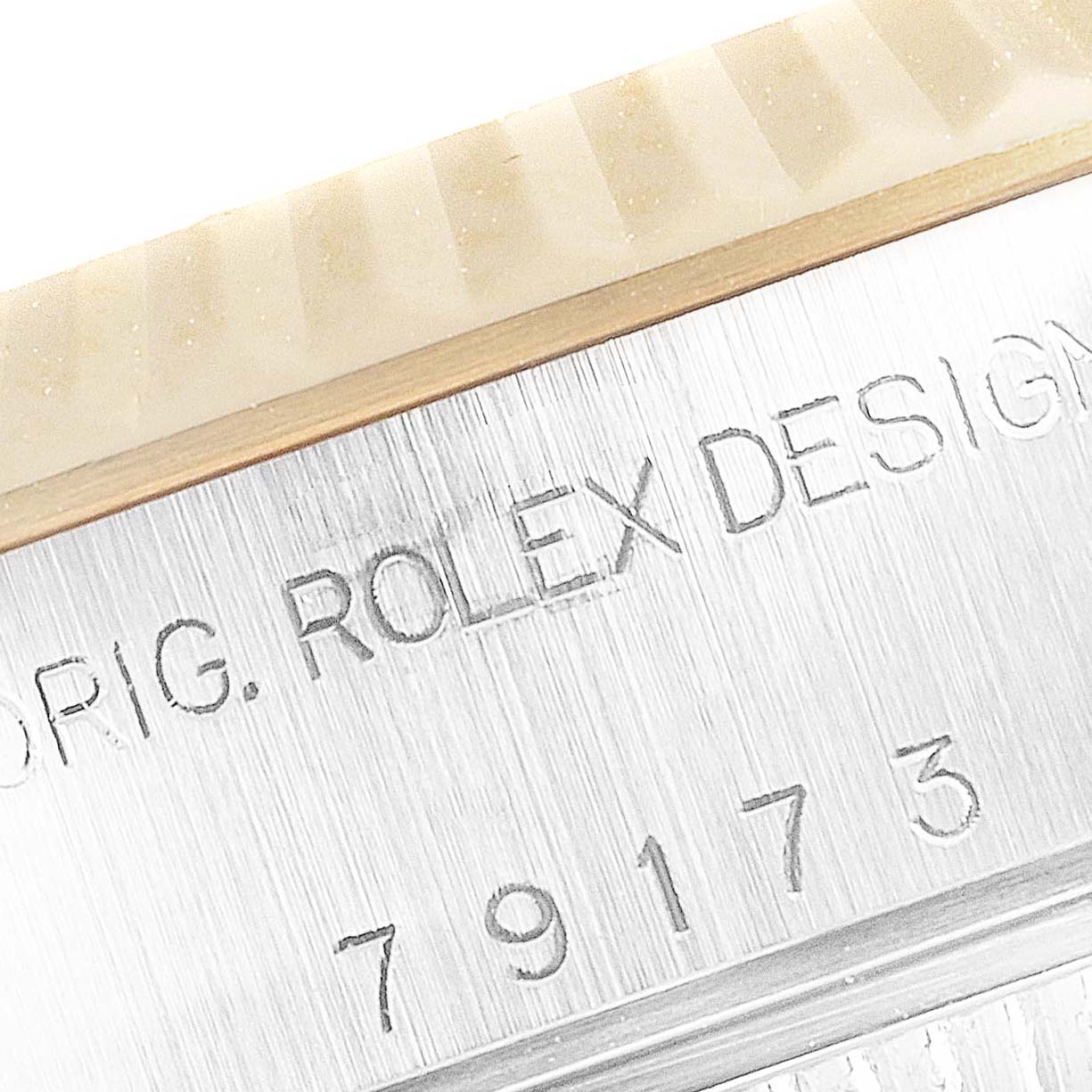 This close-up shot shows the engravings on the case, including the serial number and "ROLEX" text, of a Rolex Datejust 79173 Women's Steel and Gold (two tone) Champagne Dial 79173 Women's Steel and Gold (two tone) Champagne Dial watch.