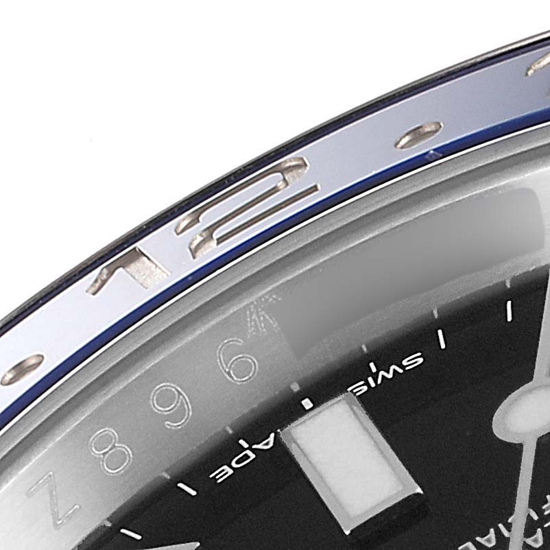 The image shows the bezel and partial dial of a Rolex GMT-Master 116710 Men's Stainless Steel Black Dial 116710 Men's Stainless Steel Black Dial watch, focusing on the 12 o'clock marker.