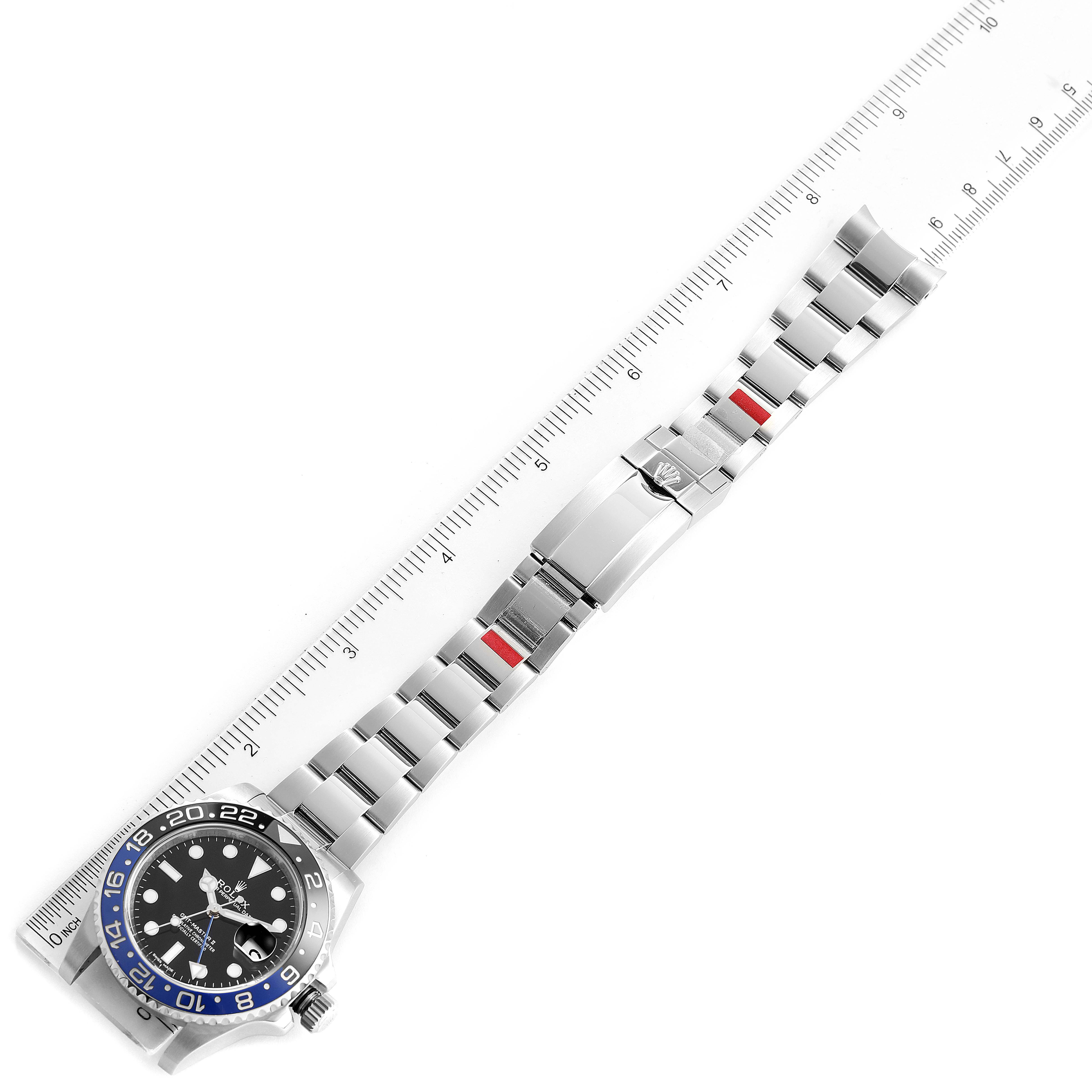 The image shows a Rolex GMT-Master 116710 Men's Stainless Steel Black Dial 116710 Men's Stainless Steel Black Dial watch laid flat, displaying the face, bezel, and metal bracelet against a ruler.