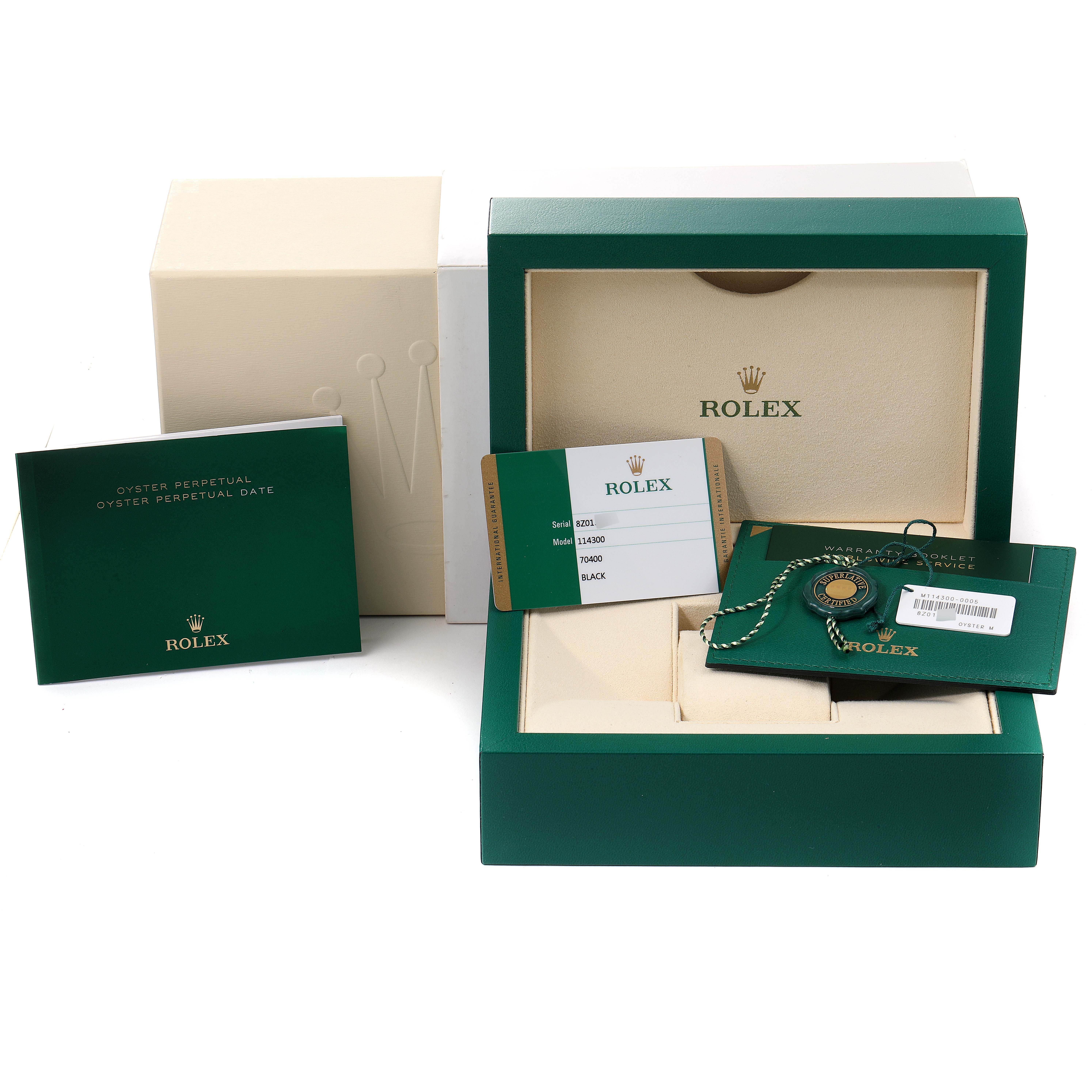 The image shows the packaging and accessories of a Rolex Oyster Perpetual 114300 Men
s Stainless Steel Black Dial 114300 Men
s Stainless Steel Black Dial watch, including the box, warranty card, tag, and booklet.
