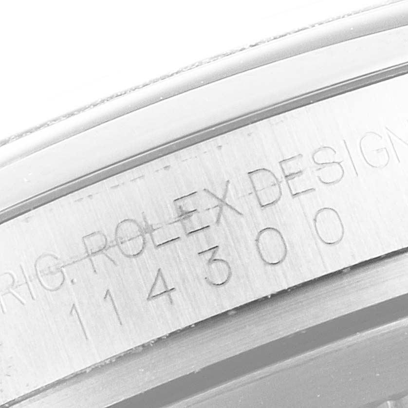 This close-up image shows the engraving on the case of a Rolex Oyster Perpetual 114300 Men
s Stainless Steel Black Dial 114300 Men
s Stainless Steel Black Dial model.