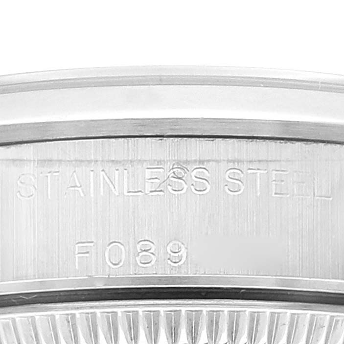 This image shows a close-up of the back case of a Rolex Oyster Perpetual 76080 Women's Stainless Steel Black Dial 76080 Women's Stainless Steel Black Dial, highlighting the "STAINLESS STEEL" engraving and partial serial number.