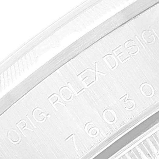 The image shows a close-up of the engraved casing of a Rolex Oyster Perpetual 76030 Women
s Stainless Steel Silver Dial 76030 Women
s Stainless Steel Silver Dial watch with model number and brand details.