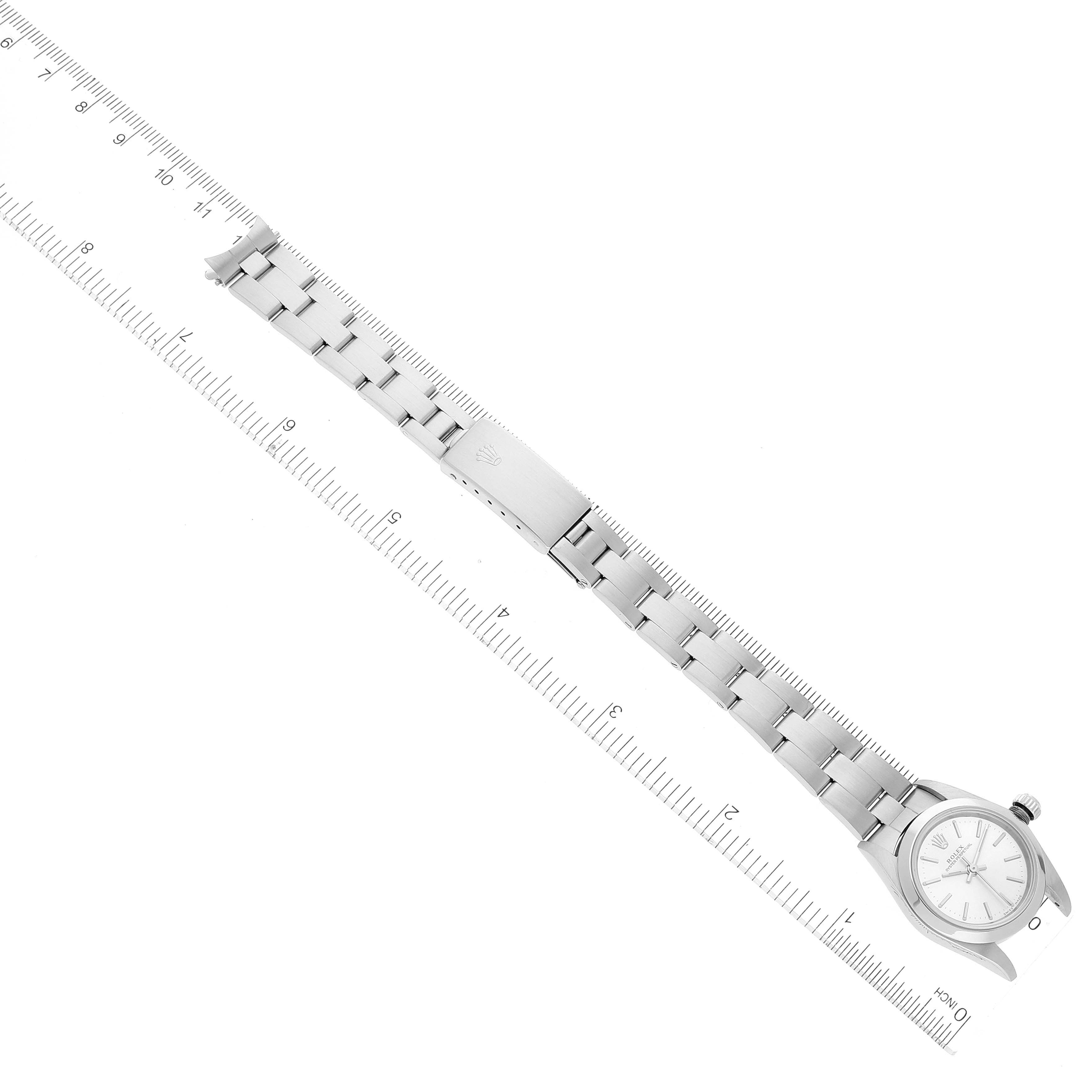 The image shows a Rolex Oyster Perpetual 76080 Women
s Stainless Steel Silver Dial 76080 Women
s Stainless Steel Silver Dial watch laying flat with a ruler, displaying the full bracelet and face from a top-down angle.