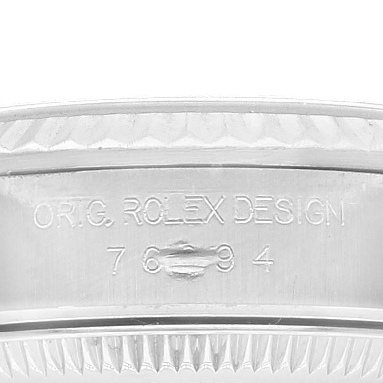 This image shows a close-up of the bezel and engraved side of the case back of a Rolex Oyster Perpetual 76094 Women
s Stainless Steel Blue Dial 76094 Women
s Stainless Steel Blue Dial watch.